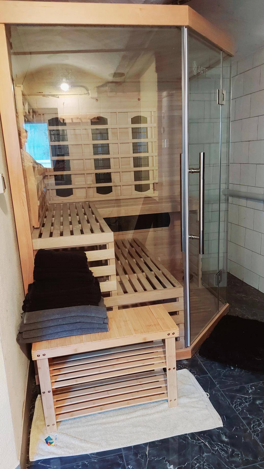 Moderne Sauna mit Holzbänken und Glastür, bereit für entspannende Momente und Erholung.