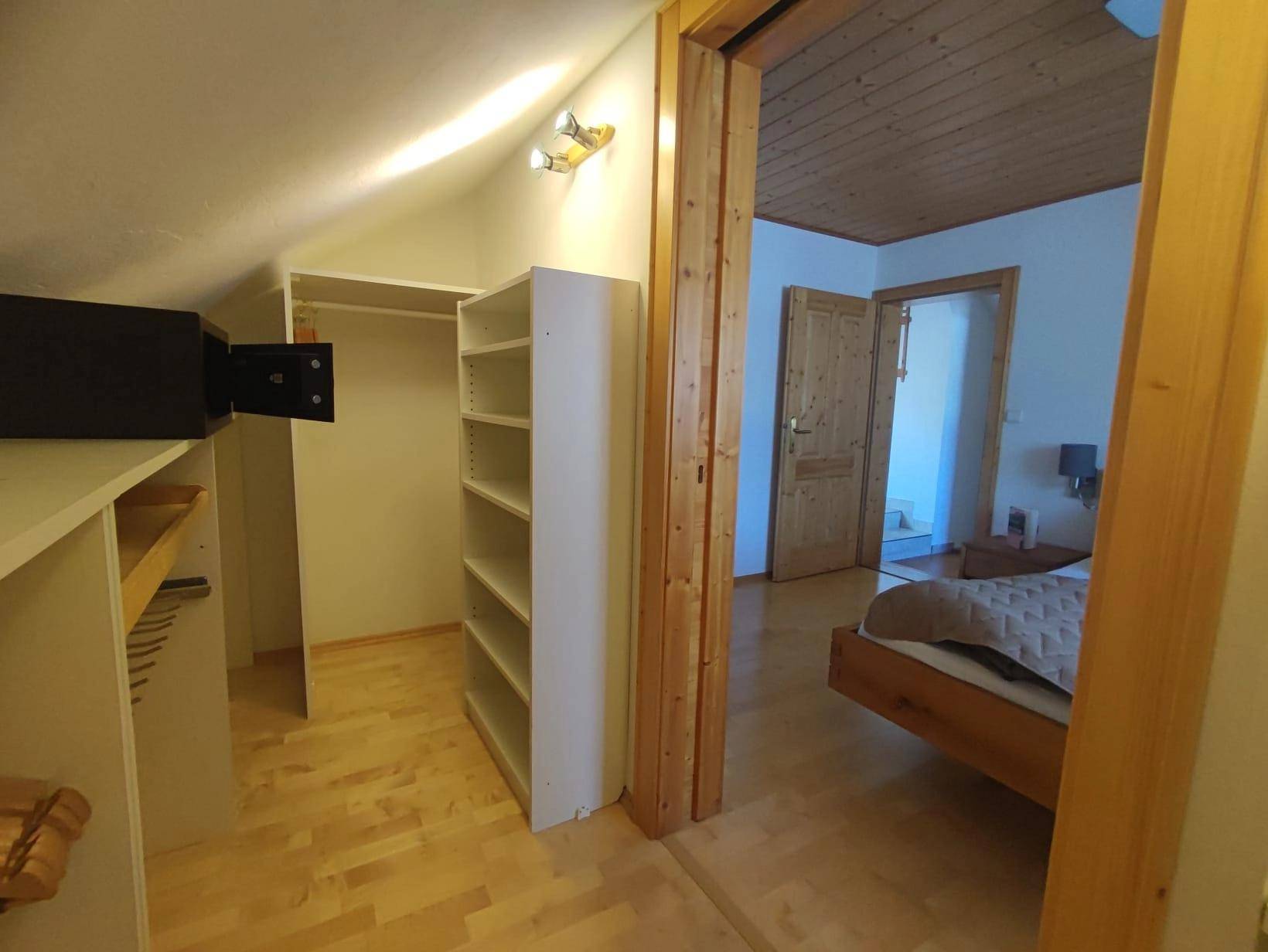 Begehbarer Kleiderschrank mit Regalen und direktem Zugang zum Schlafzimmer.