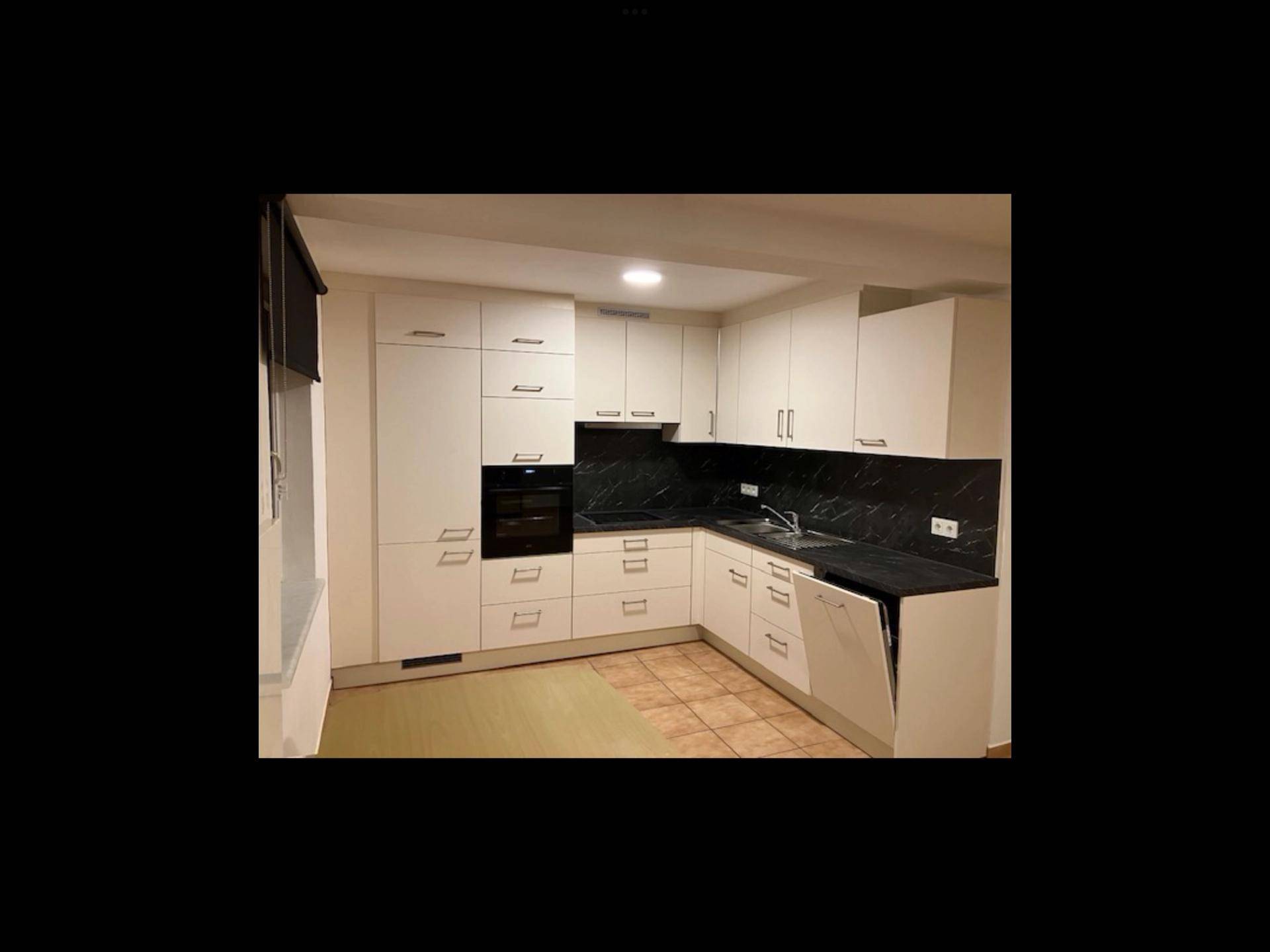 Geräumiger Essbereich mit großem Holztisch, Schränken und Fliesenboden, hell beleuchtet.