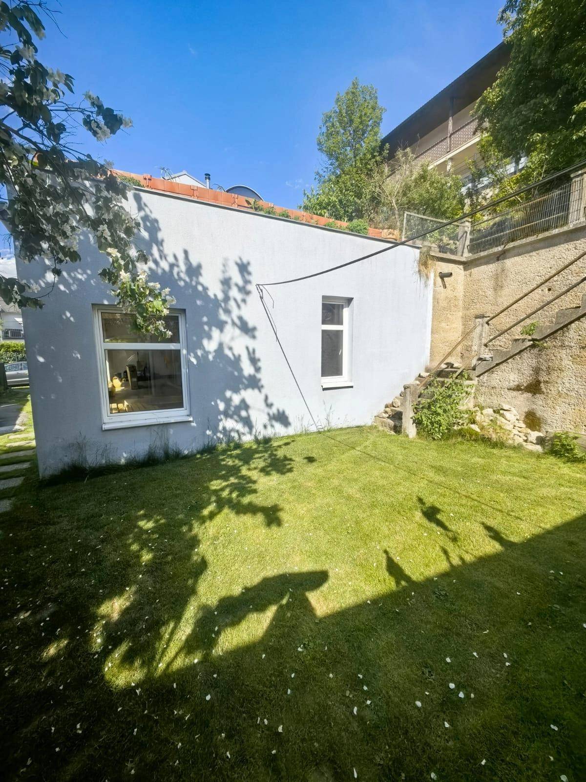 Gemütliches Wohnzimmer mit Holzboden, Kaminofen und Zugang zur sonnigen Terrasse.