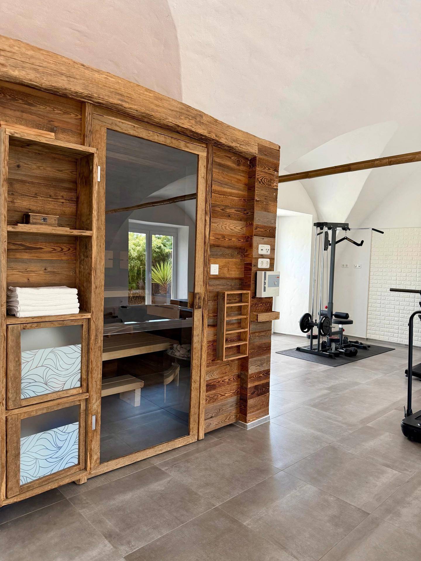 Helles Schlafzimmer mit gewölbter Decke, Holzboden und einem modernen Spiegelschrank, sehr einladend.