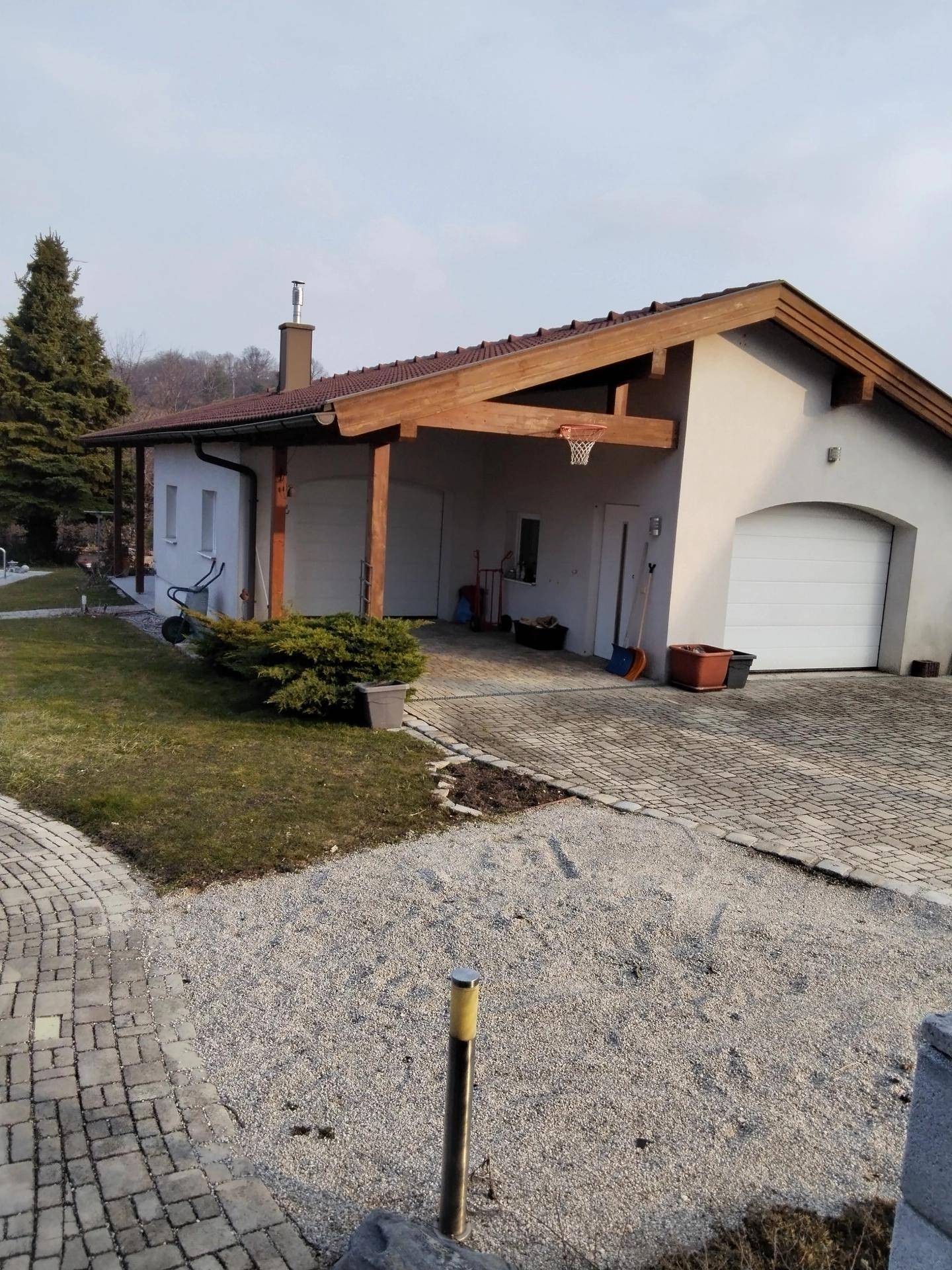 Separate Garage mit Carport und gepflasterter Zufahrt neben dem Hauptgebäude.