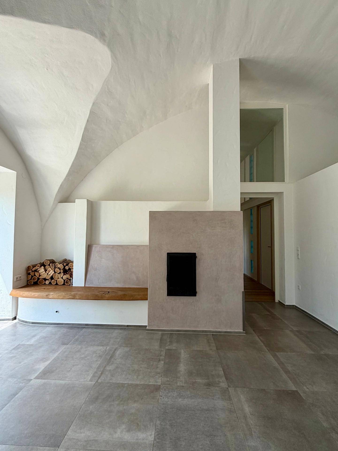 Entspannungsbereich mit Whirlpool, gewölbter Decke und großen Fenstern zum Garten, sehr hell.