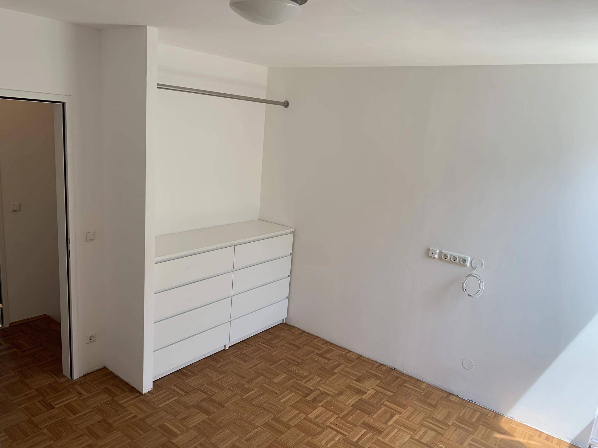 Schlafzimmer mit integriertem Kleiderschrank und Parkettboden, bereit zur individuellen Gestaltung.