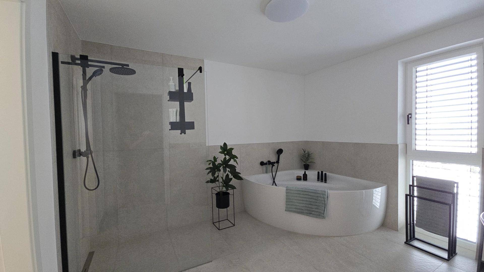 Modernes Badezimmer mit begehbarer Dusche, freistehender Badewanne und Fenster für Tageslicht.