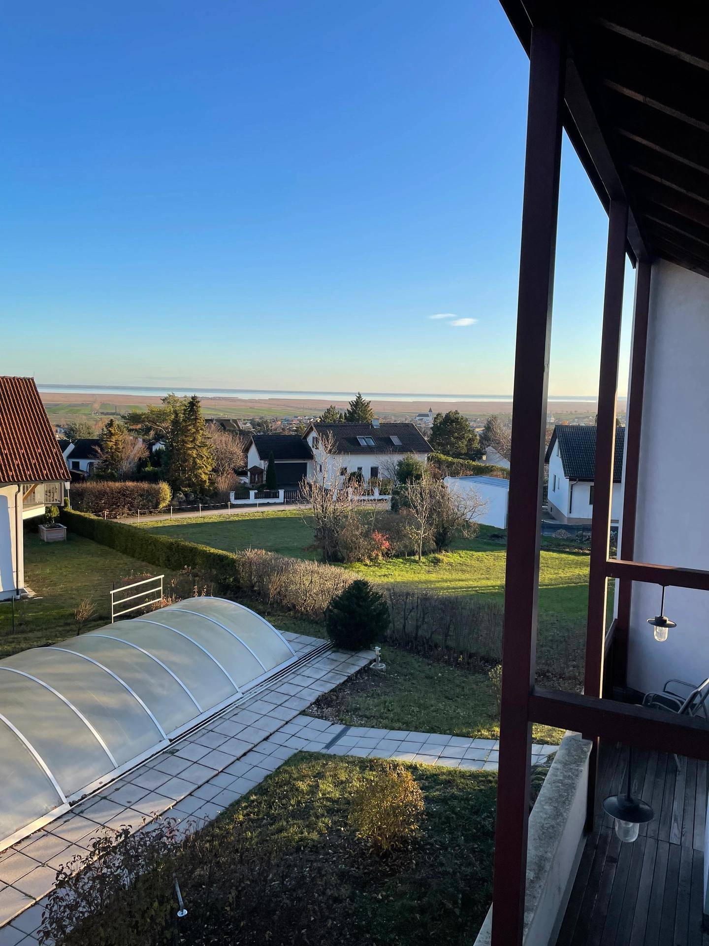 Weitläufiger Ausblick von einem Balkon über die Landschaft mit einem Pool im Vordergrund.