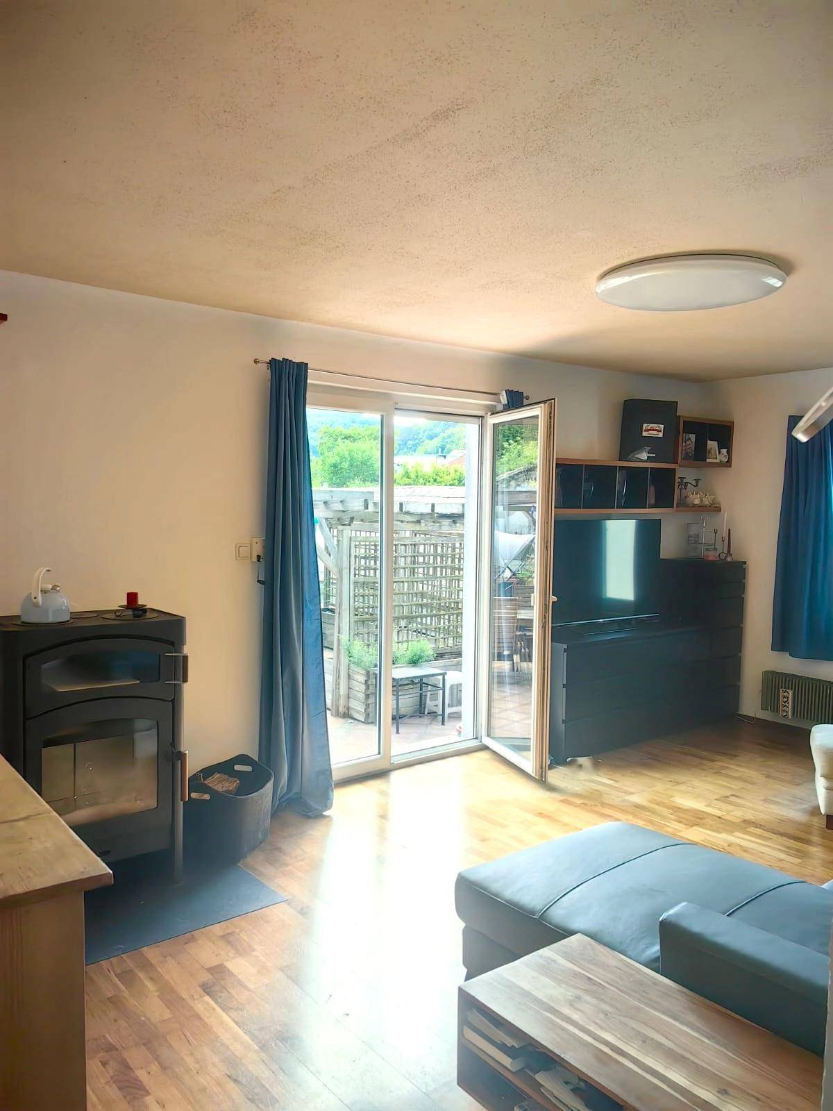 Schlafzimmer mit blauen Wänden, Holzboden und einem großen Spiegelschrank.