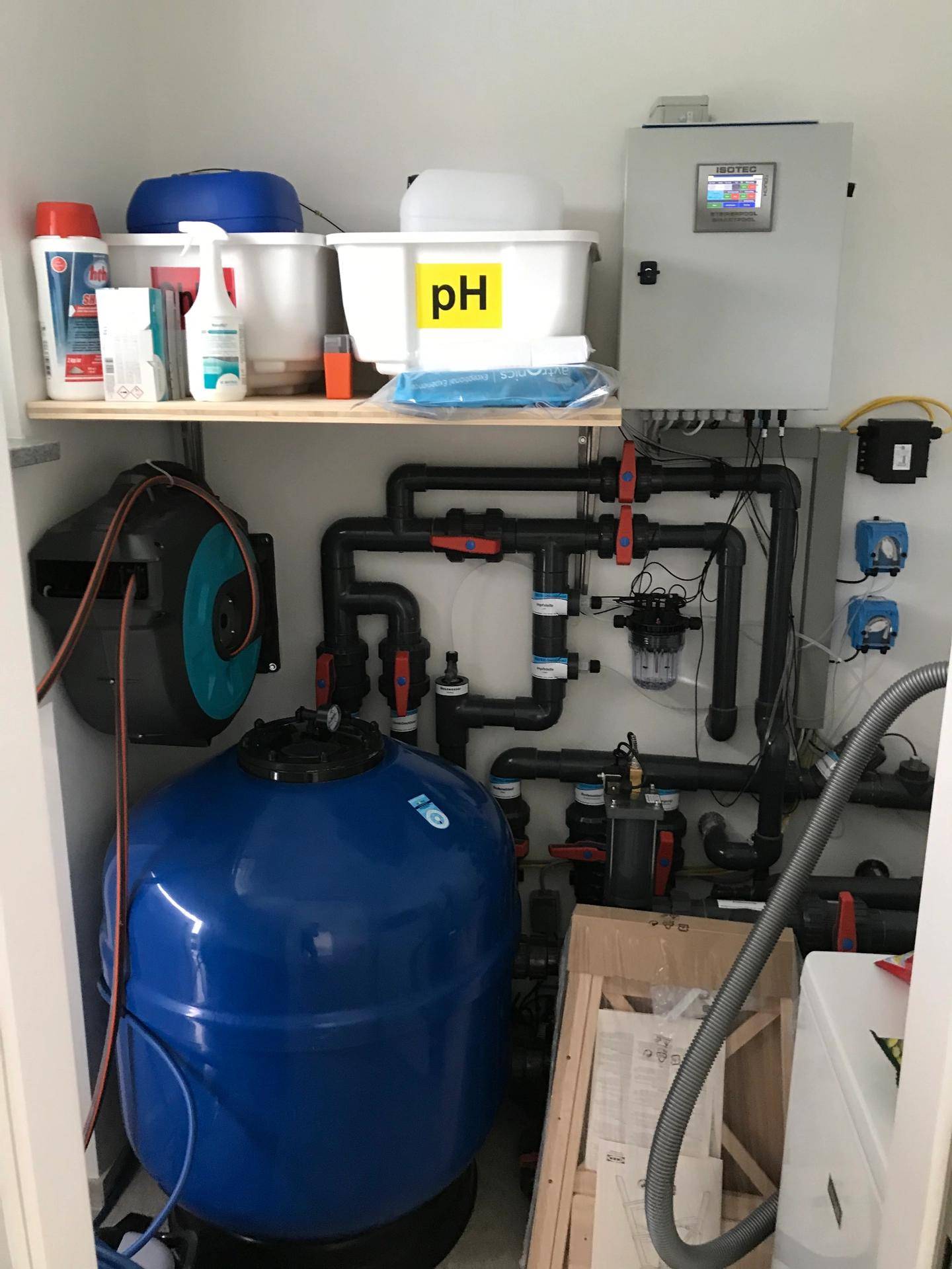 Technikraum mit Poolfilteranlage, Pumpen und verschiedenen Wartungsprodukten.