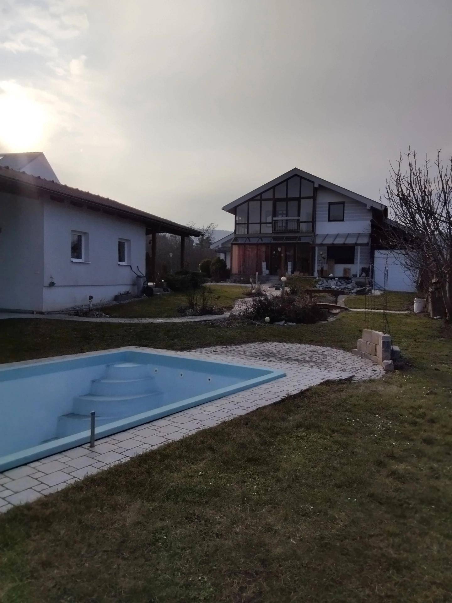 Gartenbereich mit eingelassenem Pool und Blick auf das moderne Wohnhaus im Hintergrund.