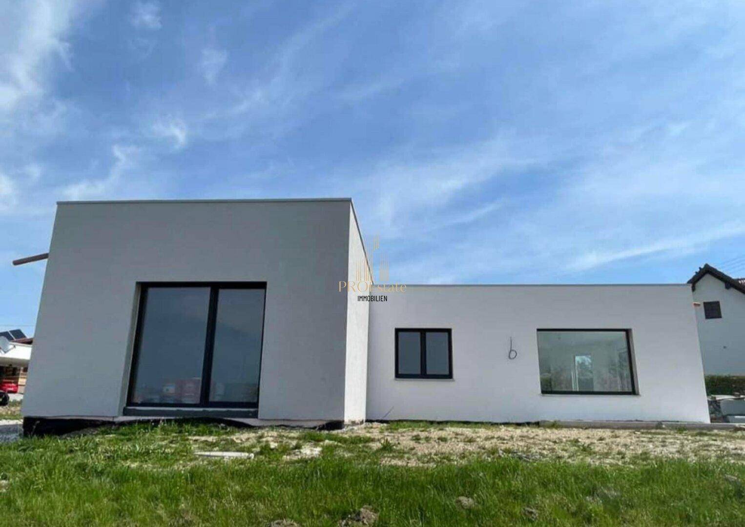 Moderne Architektur des Neubaus mit klaren Linien und großen Fensterflächen.