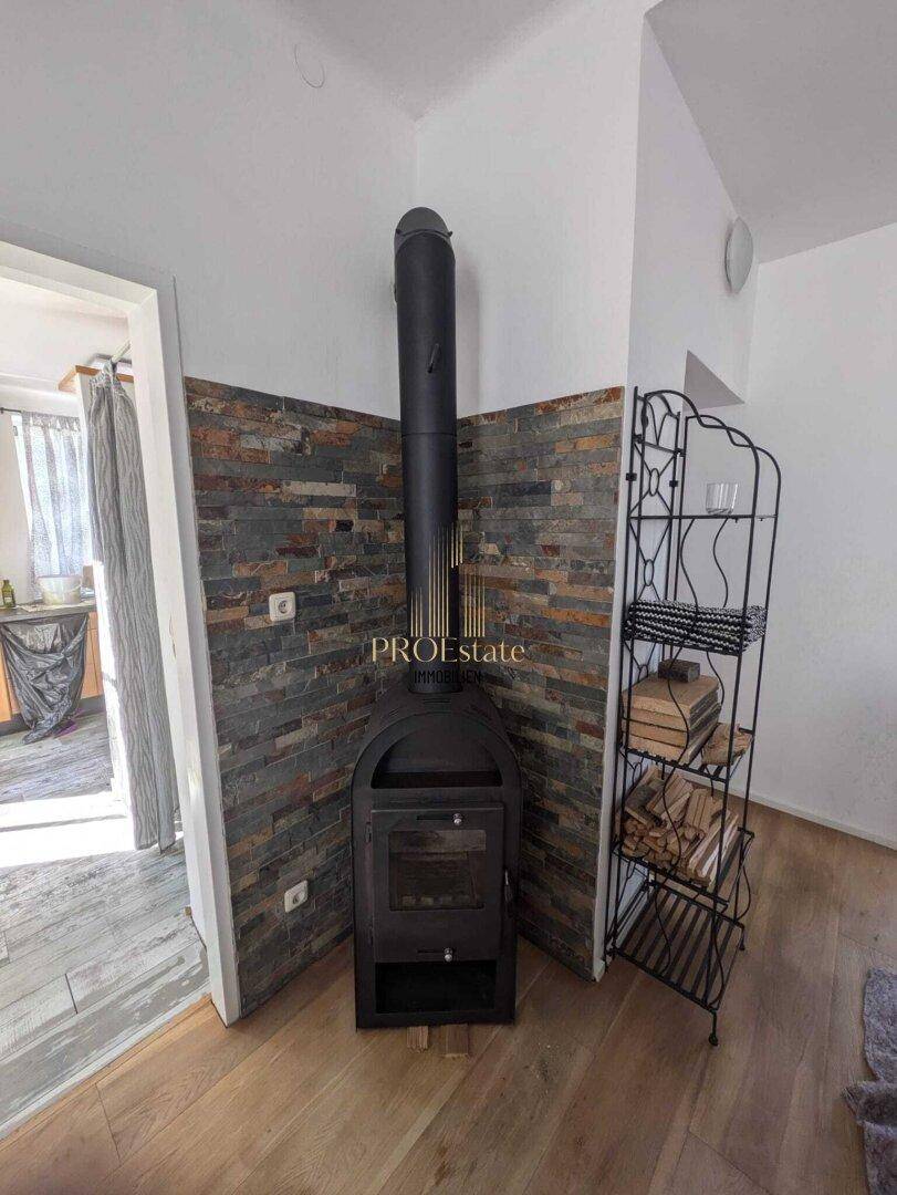 Eingangsbereich mit modernem Holzofen und dekorativer Steinwandverkleidung.