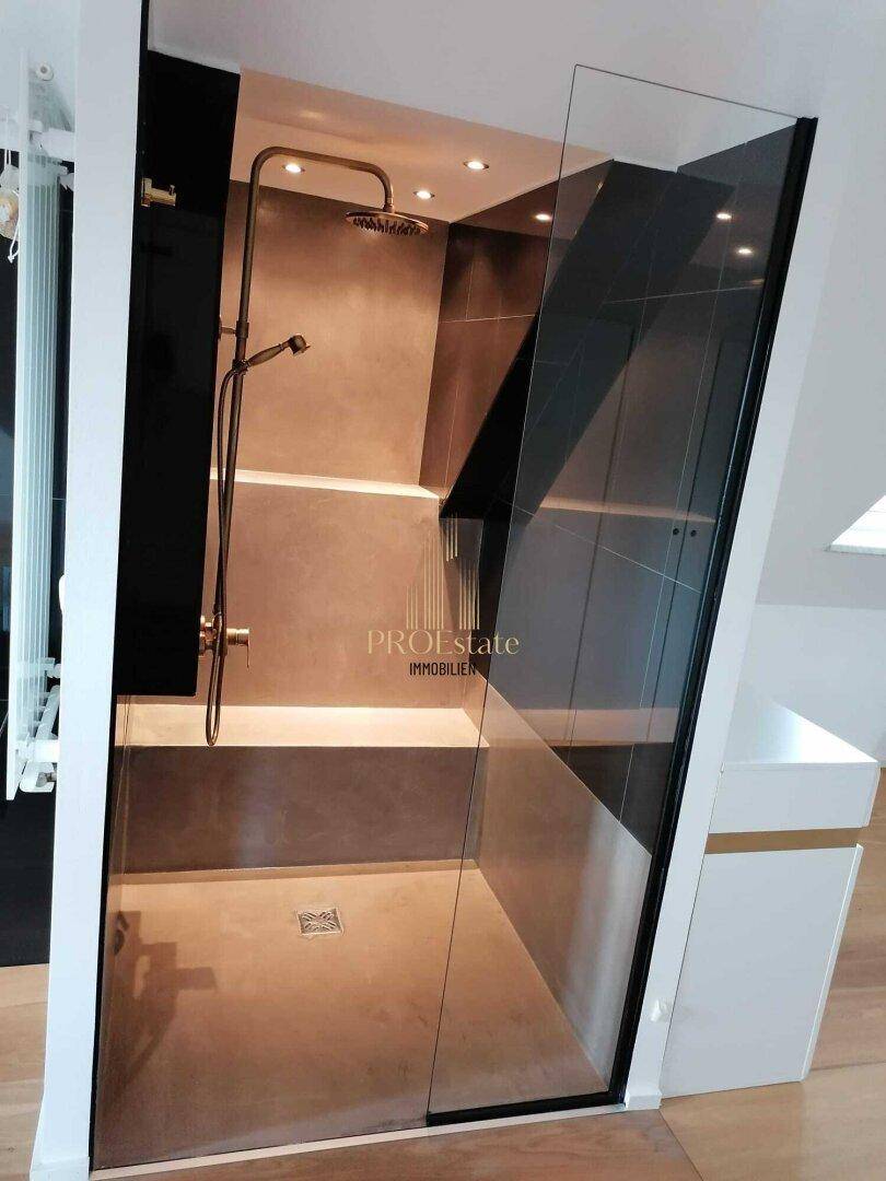 Moderne begehbare Dusche mit Glasabtrennung und Regenduschkopf in dunklem Design.