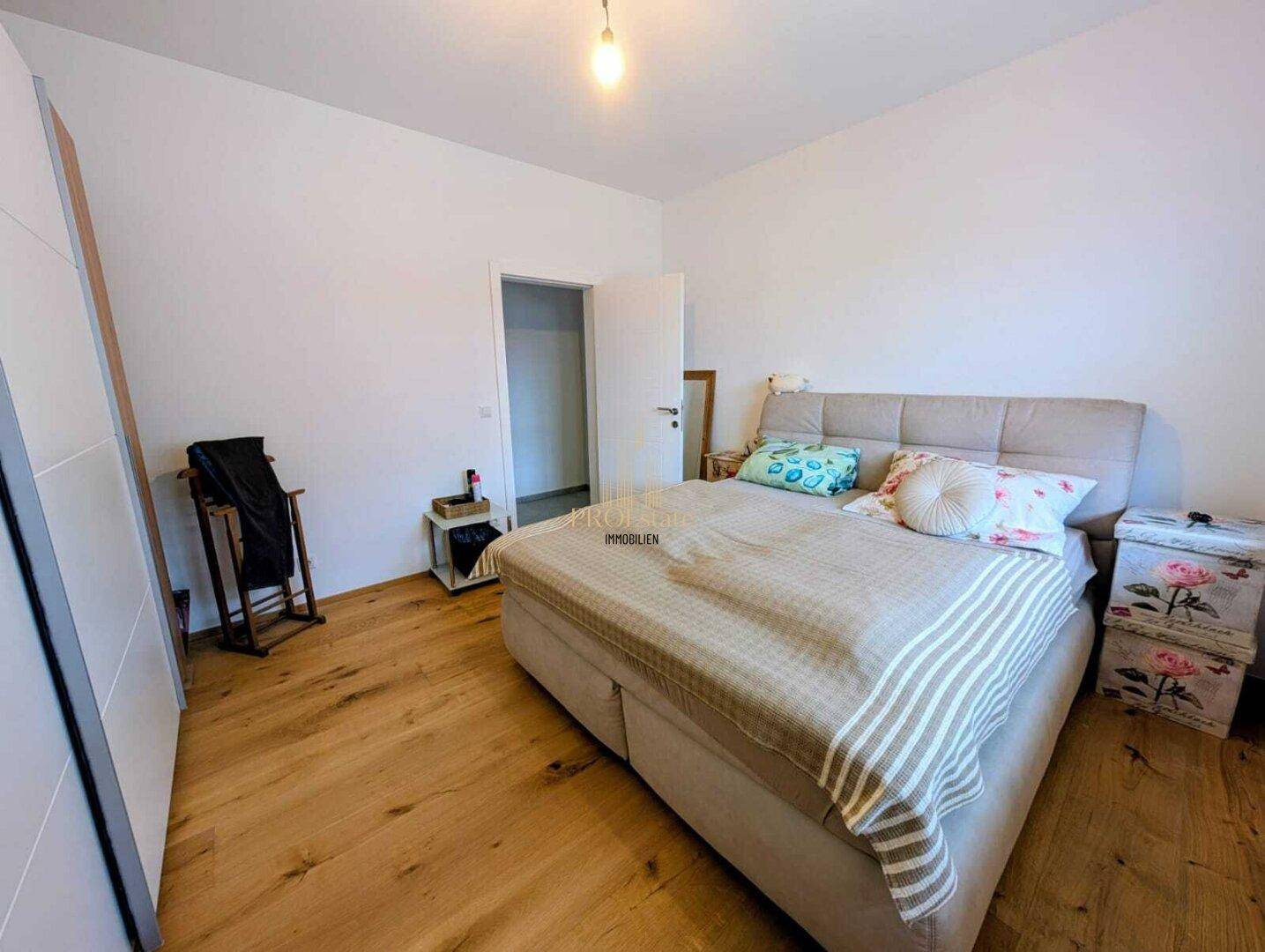 Geräumiges Schlafzimmer mit Holzboden und hellem Ambiente.