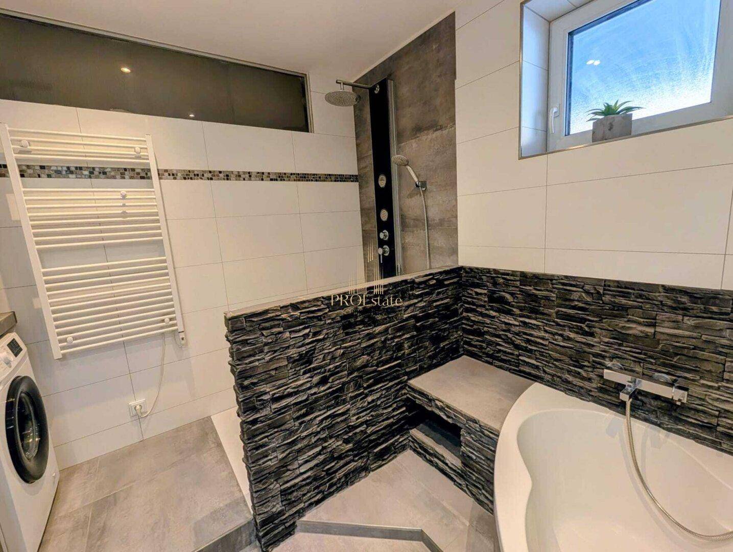 Modernes Badezimmer mit begehbarer Dusche, Badewanne und beheiztem Handtuchhalter.