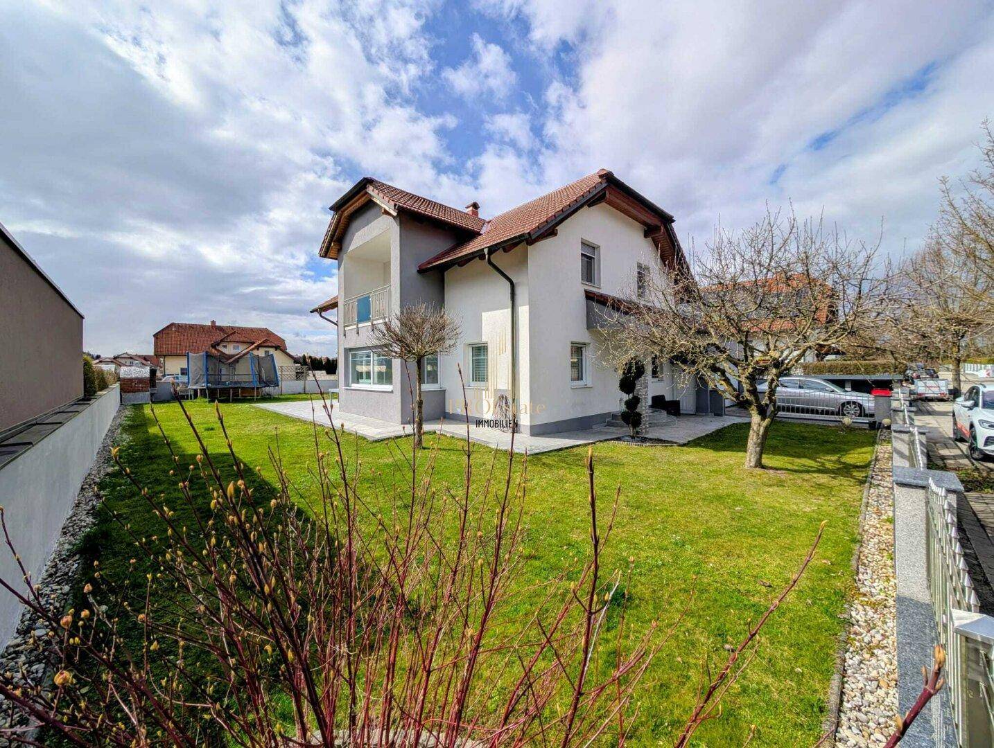Großer, gepflegter Garten mit Rasenfläche und Bäumen rund um das Einfamilienhaus.