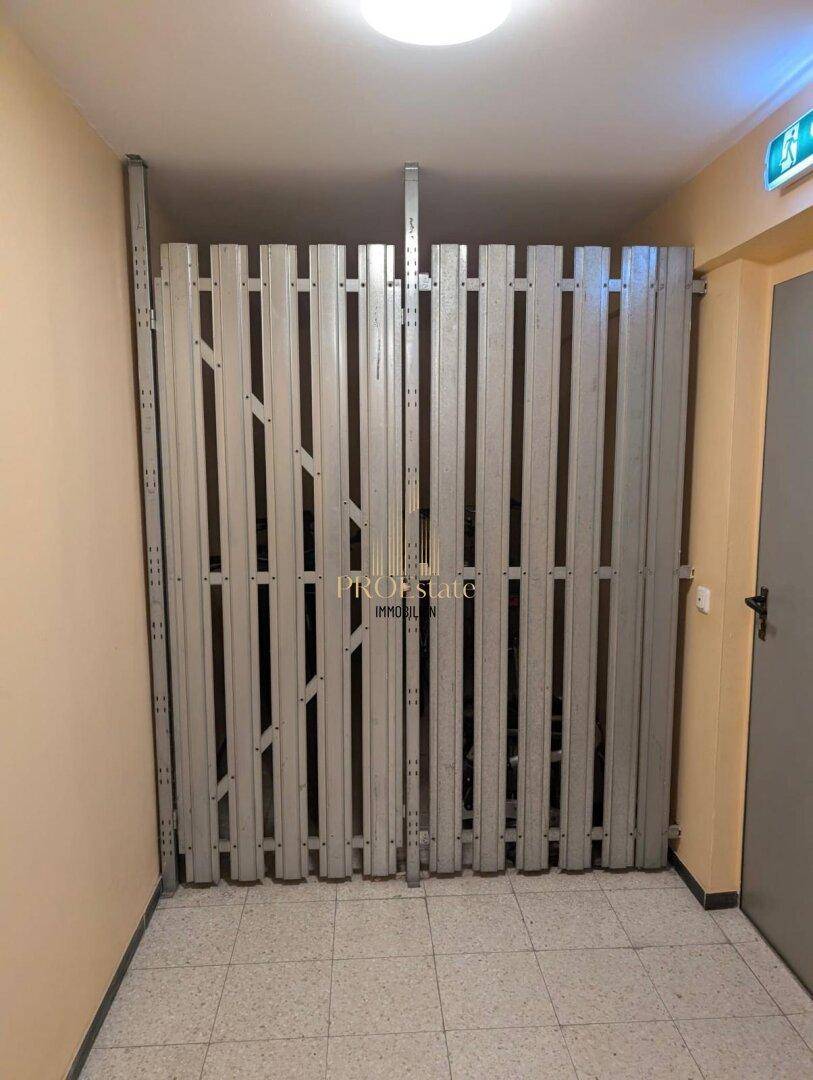 Sicherer Fahrradraum mit Metallgittertür und ausreichend Platz für Fahrräder, ideal für Bewohner.
