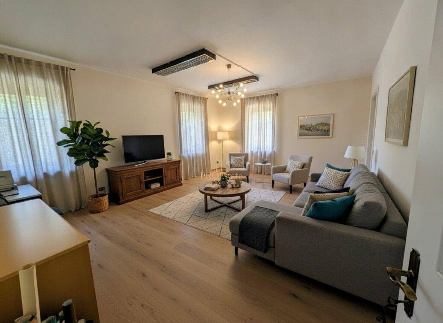 Modern eingerichtetes Wohnzimmer mit Holzboden, bequemer Couch und stilvoller Beleuchtung.