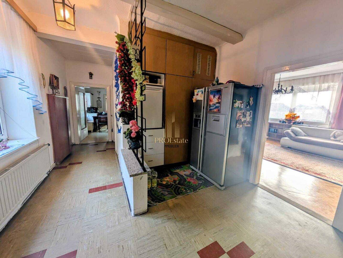 Flur mit Kühlschrank, Einbauschränken und Zugang zu weiteren Räumen.