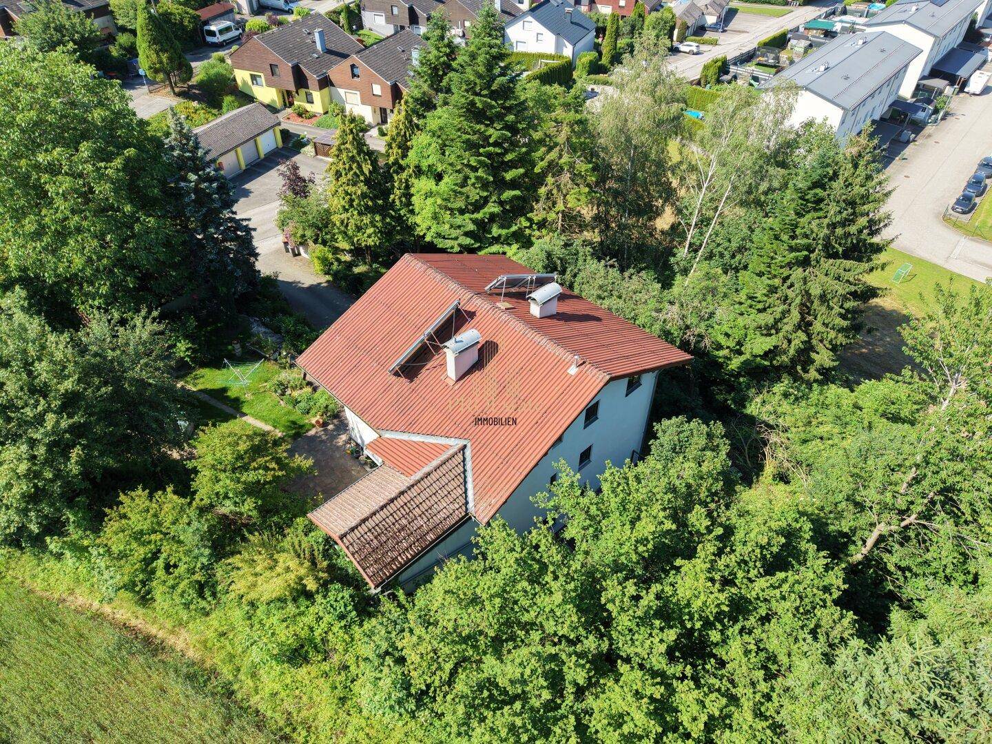 Vogelperspektive des Hauses in ländlicher Umgebung mit angrenzenden Feldern und Nachbarhäusern.