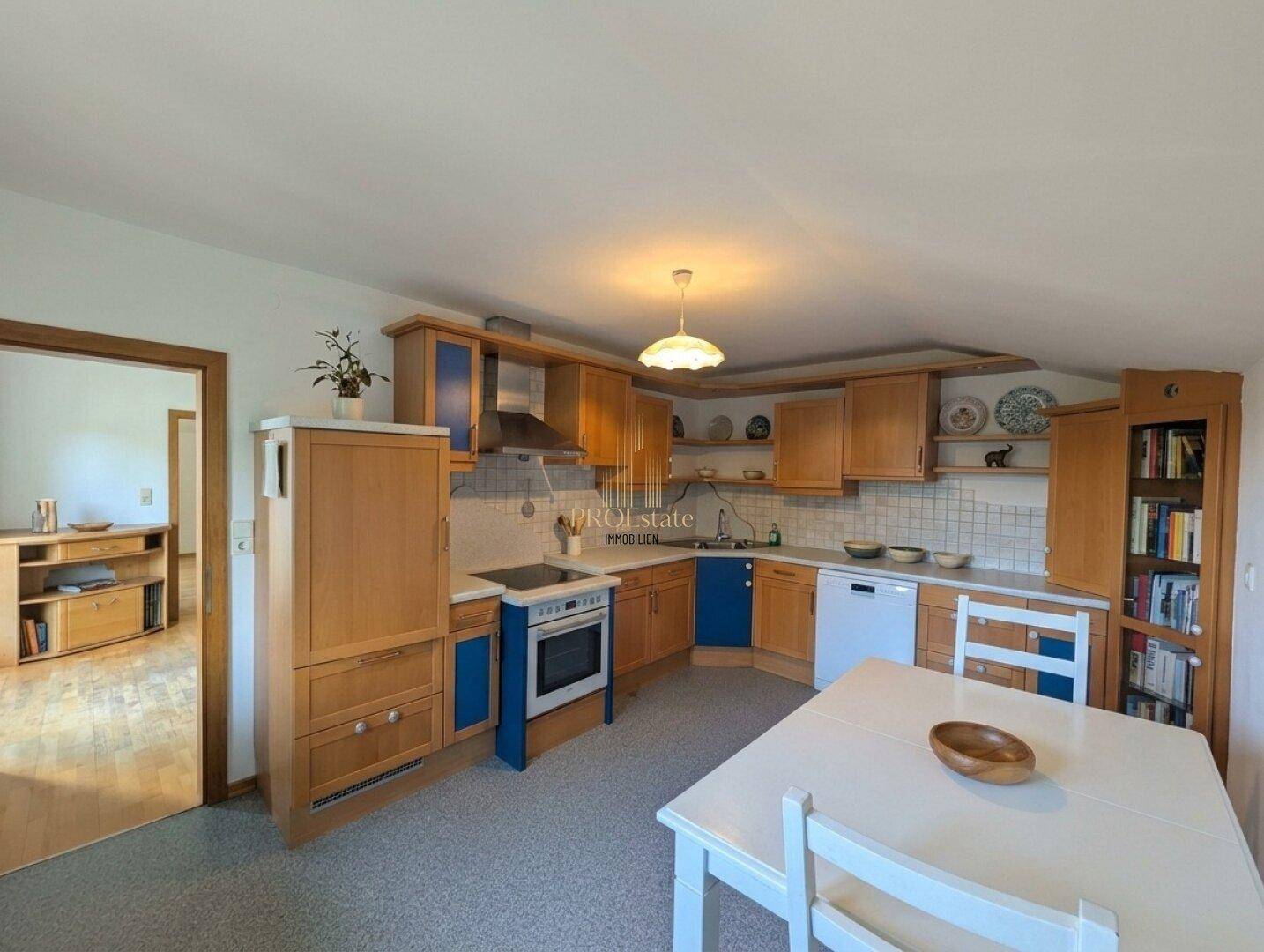 Traditionelle Küche mit Holzschränken, blauen Akzenten und einem Essbereich.