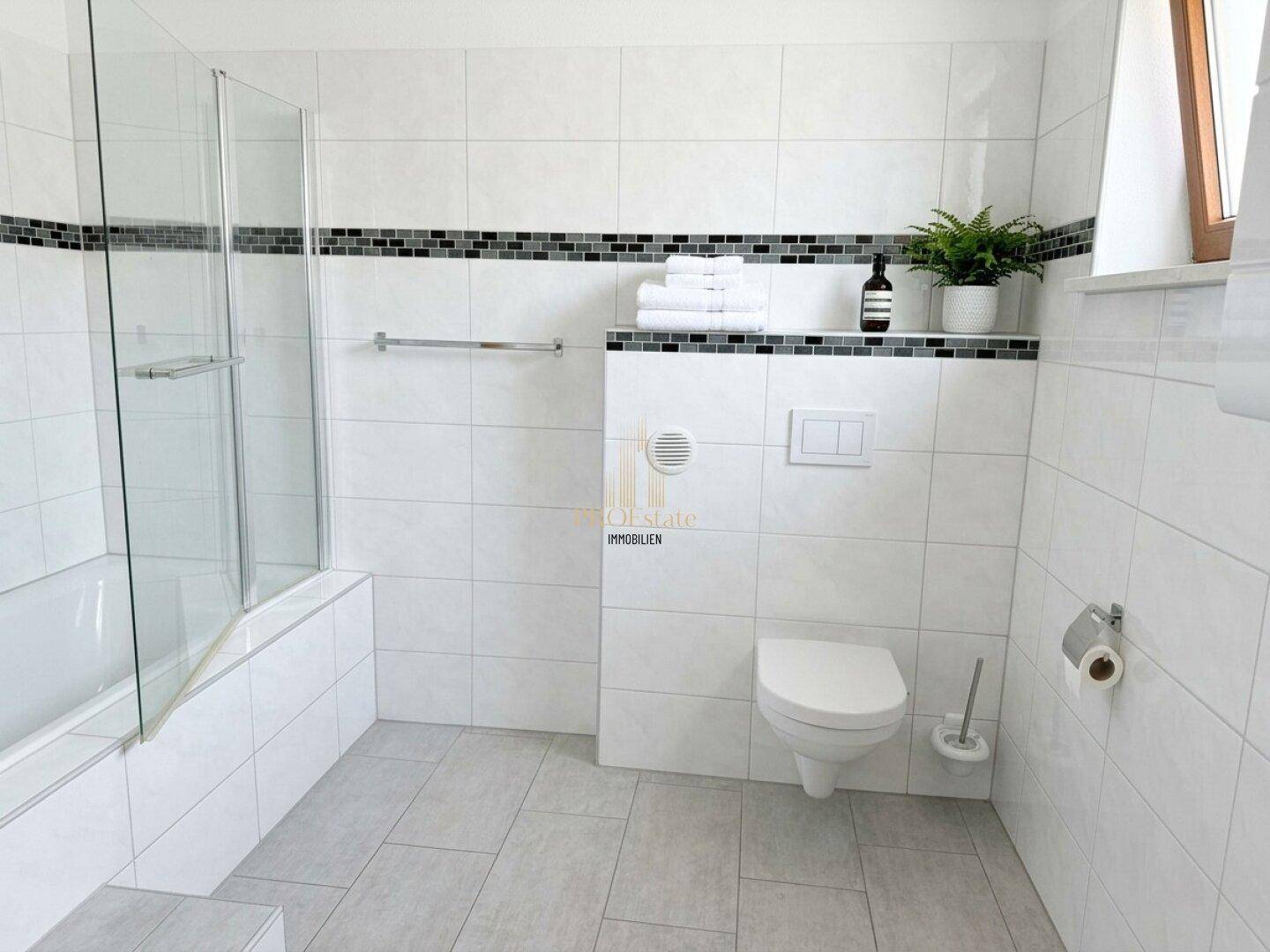 Modernes Badezimmer mit Badewanne, Wand-WC und Fenster.