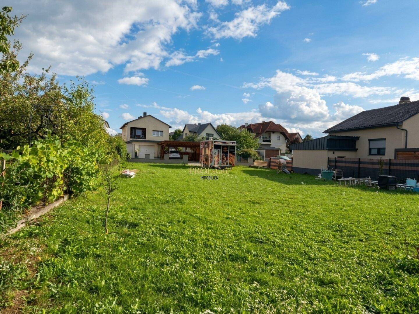 Großer, gepflegter Garten mit Rasenfläche und Blick auf die Nachbarhäuser.
