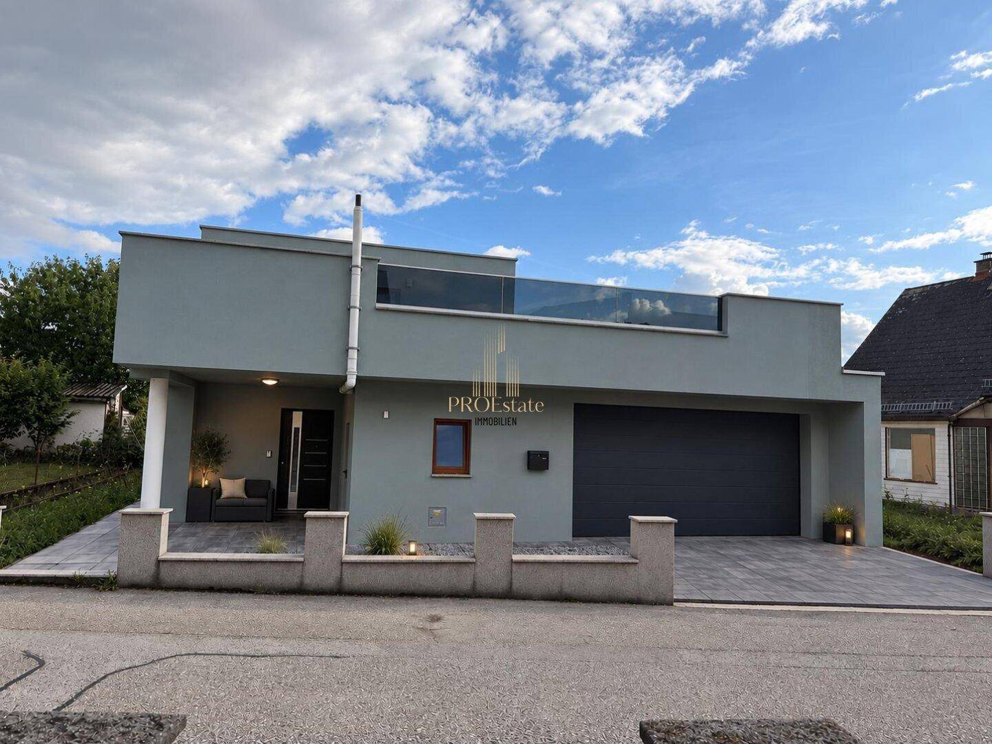 Moderne Hausfassade mit integrierter Garage und Flachdach.