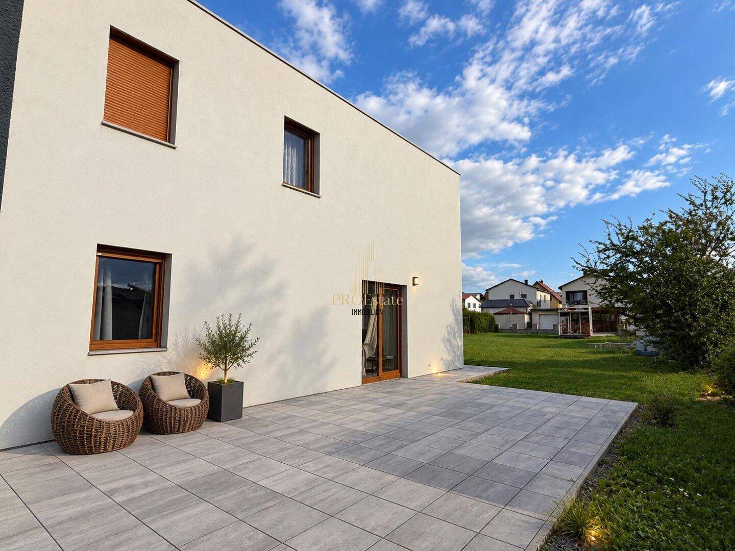 Hinterhof-Terrasse mit Sitzgelegenheiten und Blick auf den Garten.