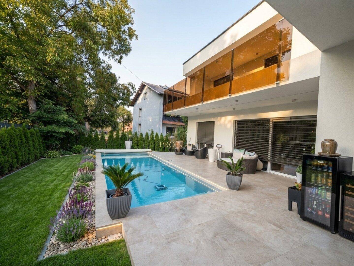 Große Terrasse mit Pool, Liegebereich und gepflegter Gartenanlage hinter einem modernen Haus.