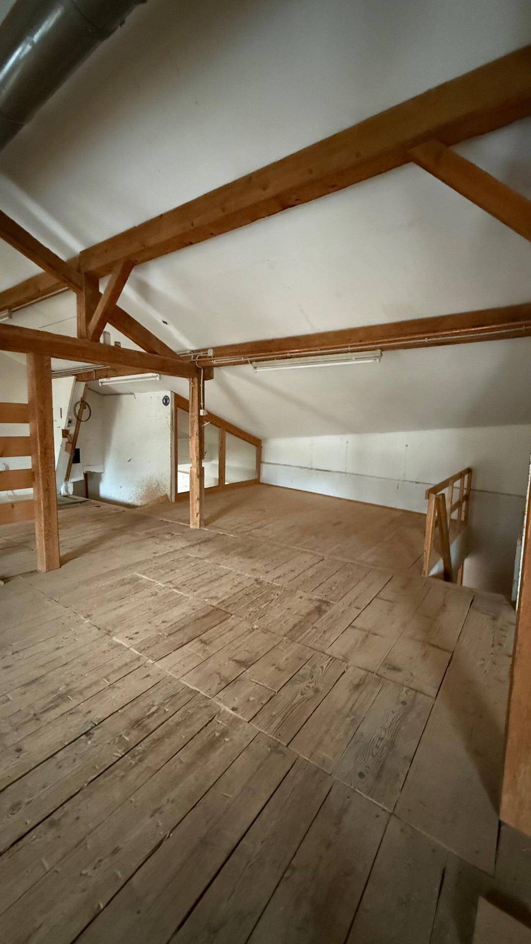 Geräumiger Dachboden mit sichtbaren Holzbalken und Holzdielenboden, bietet viel Potenzial für Ausbau.