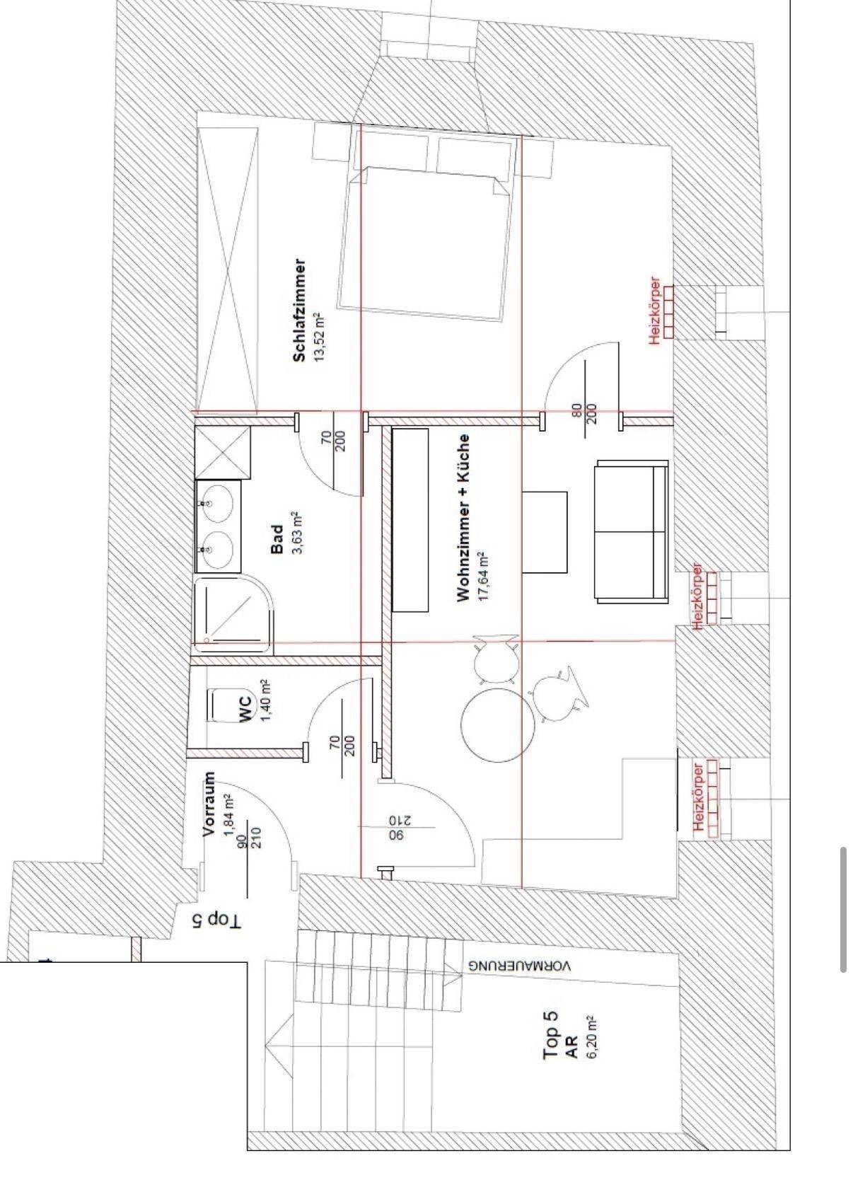 Grundriss einer Wohnung mit Schlafzimmer, Bad, WC, Vorraum und offenem Wohn- und Küchenbereich.