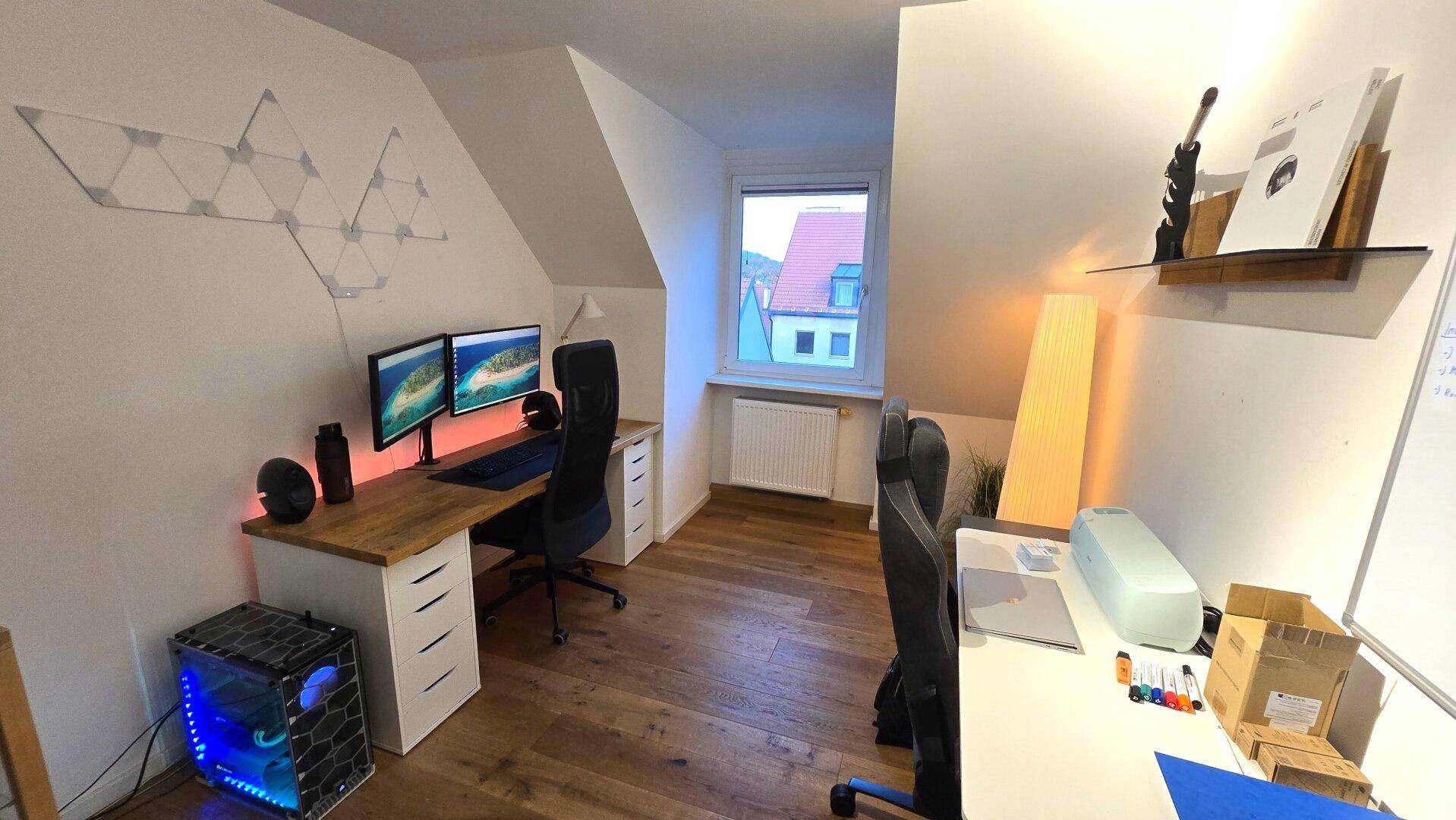 Modernes Home-Office im Dachgeschoss mit zwei Arbeitsplätzen und Holzboden.