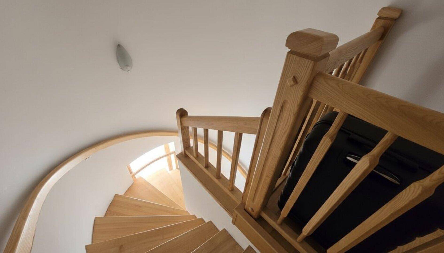 Elegante Holzwendeltreppe mit natürlichem Lichteinfall, die die Etagen verbindet.
