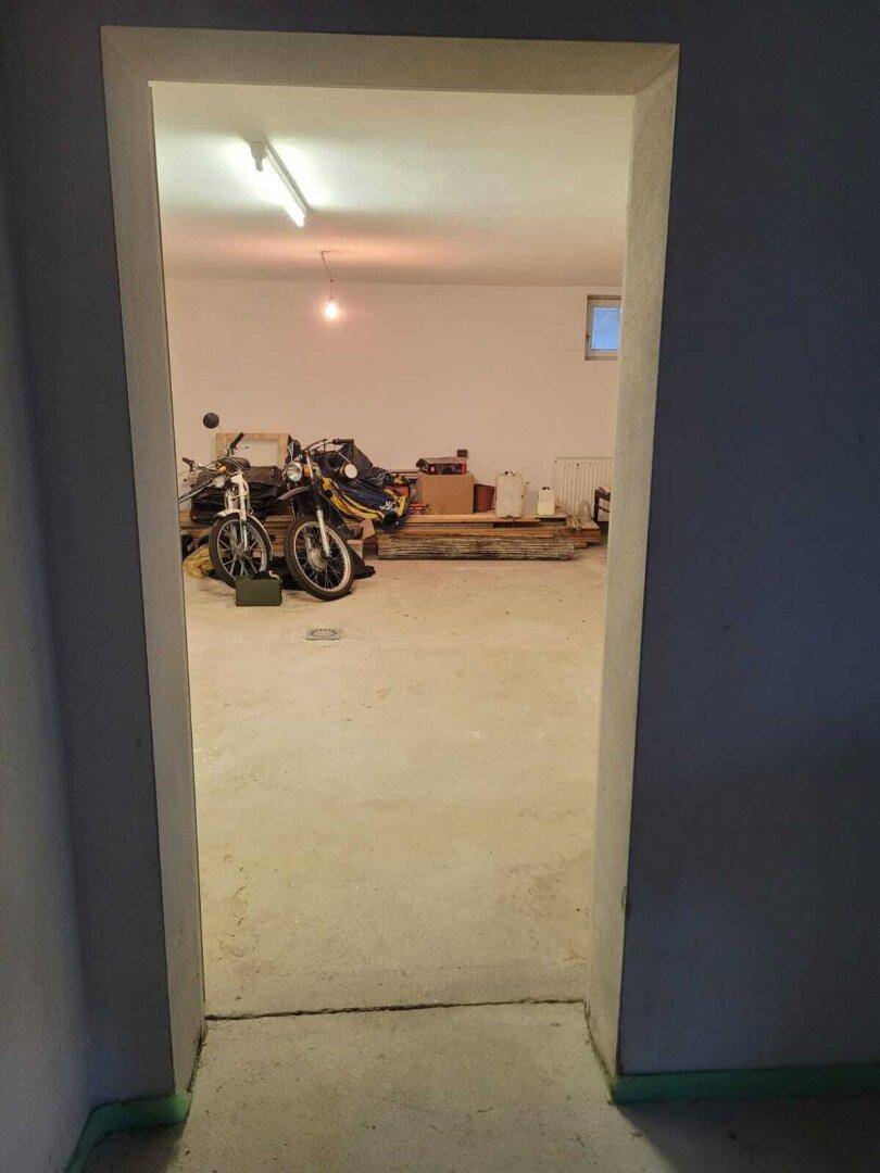 Geräumiger Kellerraum mit Betonboden, ideal als Lagerfläche oder Werkstatt.