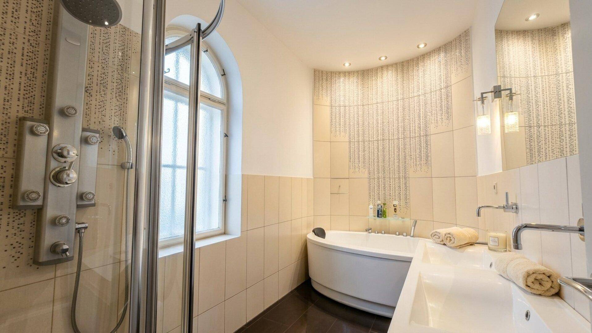 Modernes Badezimmer mit Dusche, Eckbadewanne und Doppelwaschbecken.