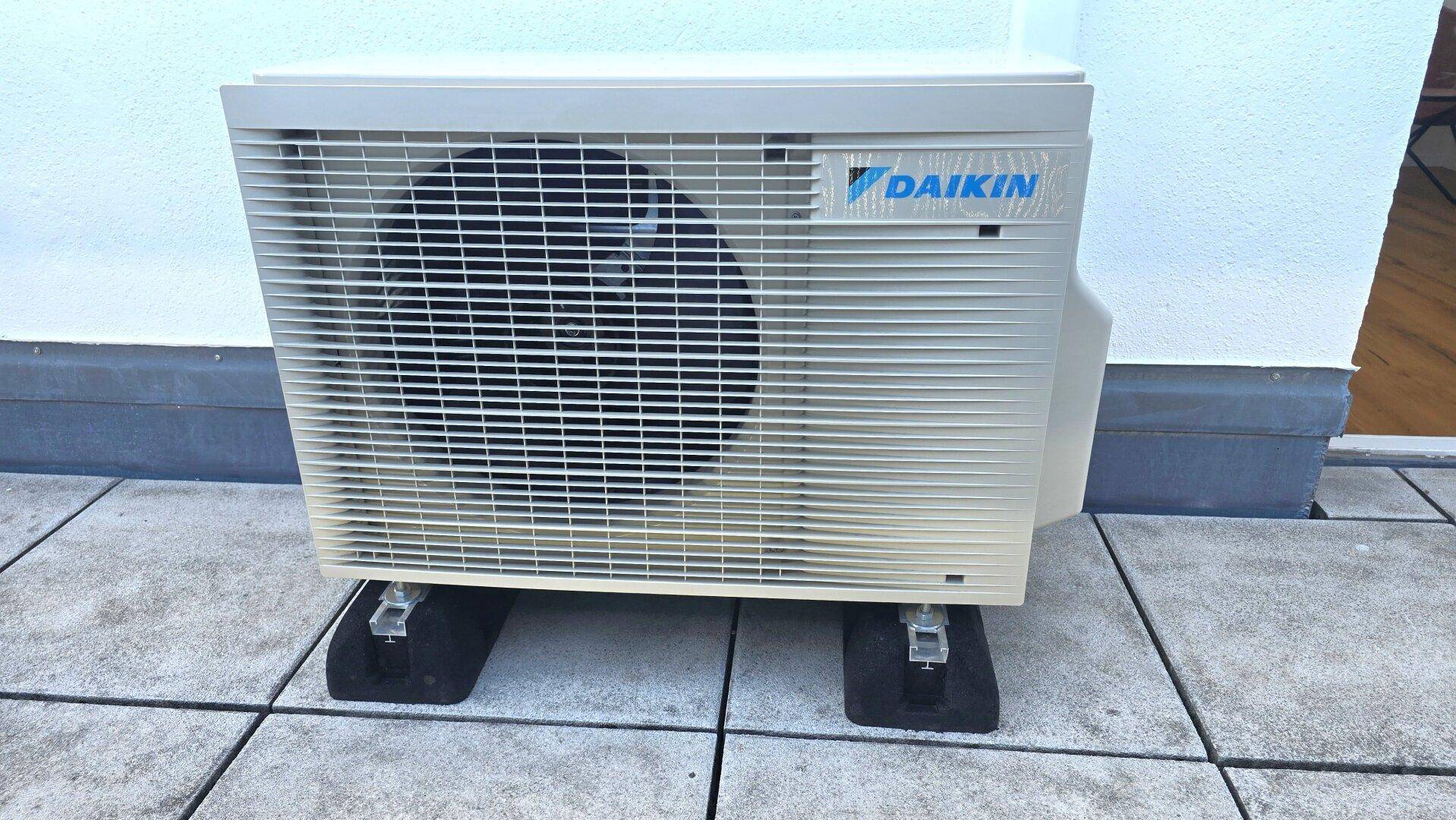 Außenklimaanlage auf einer gefliesten Terrasse, die für Kühlung sorgt.