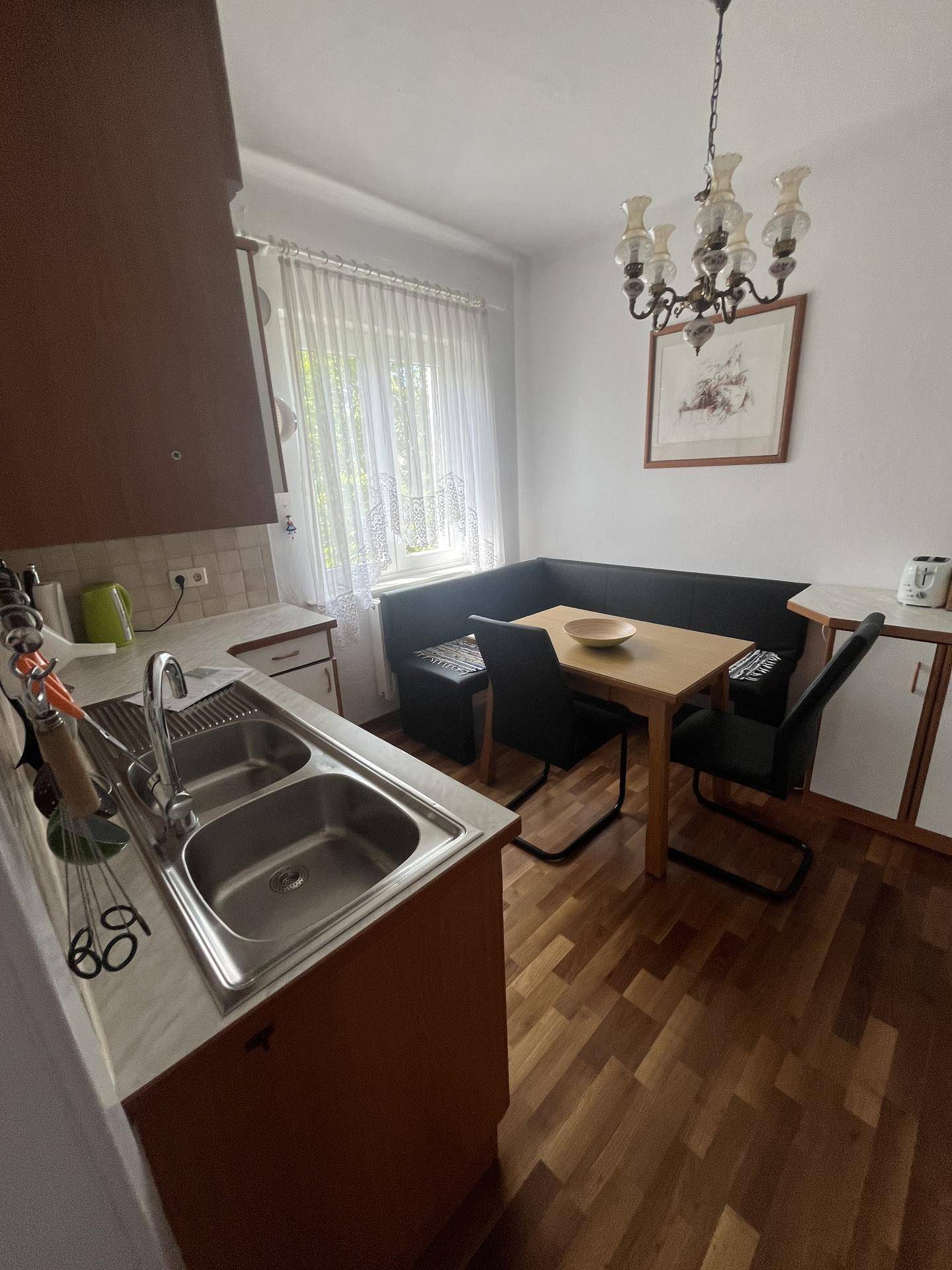 Gemütliche Küche mit Holzboden, Eckbank und Esstisch, ideal für gemeinsame Mahlzeiten.