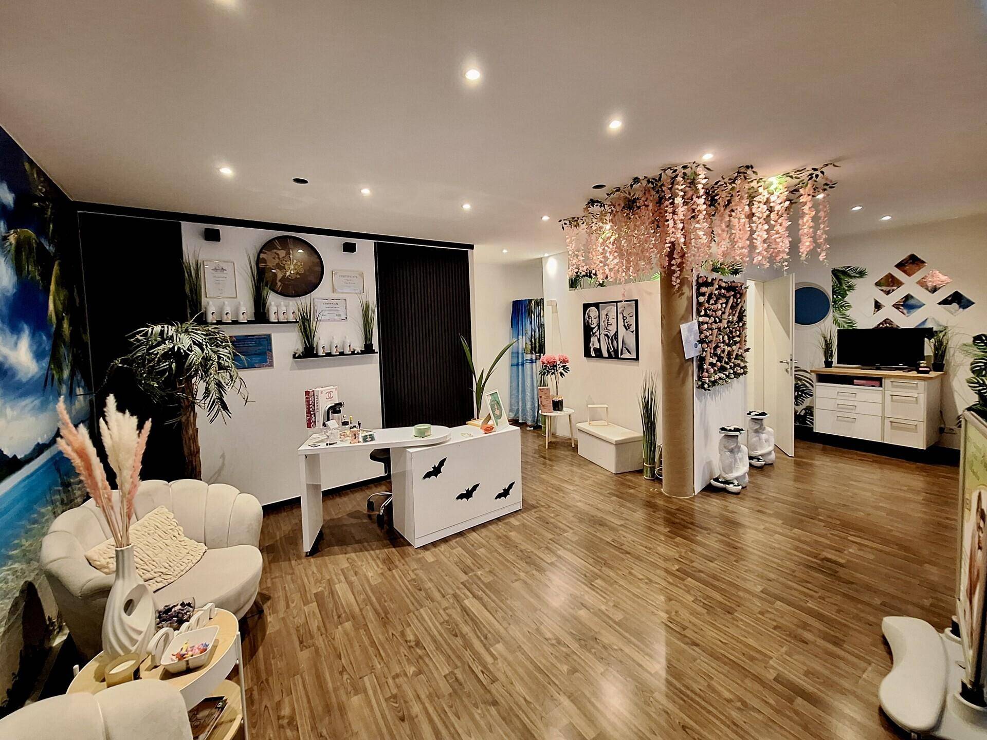 Heller Empfangsbereich eines Geschäfts mit modernem Design, Holzboden und floralen Dekorationen an der Decke.