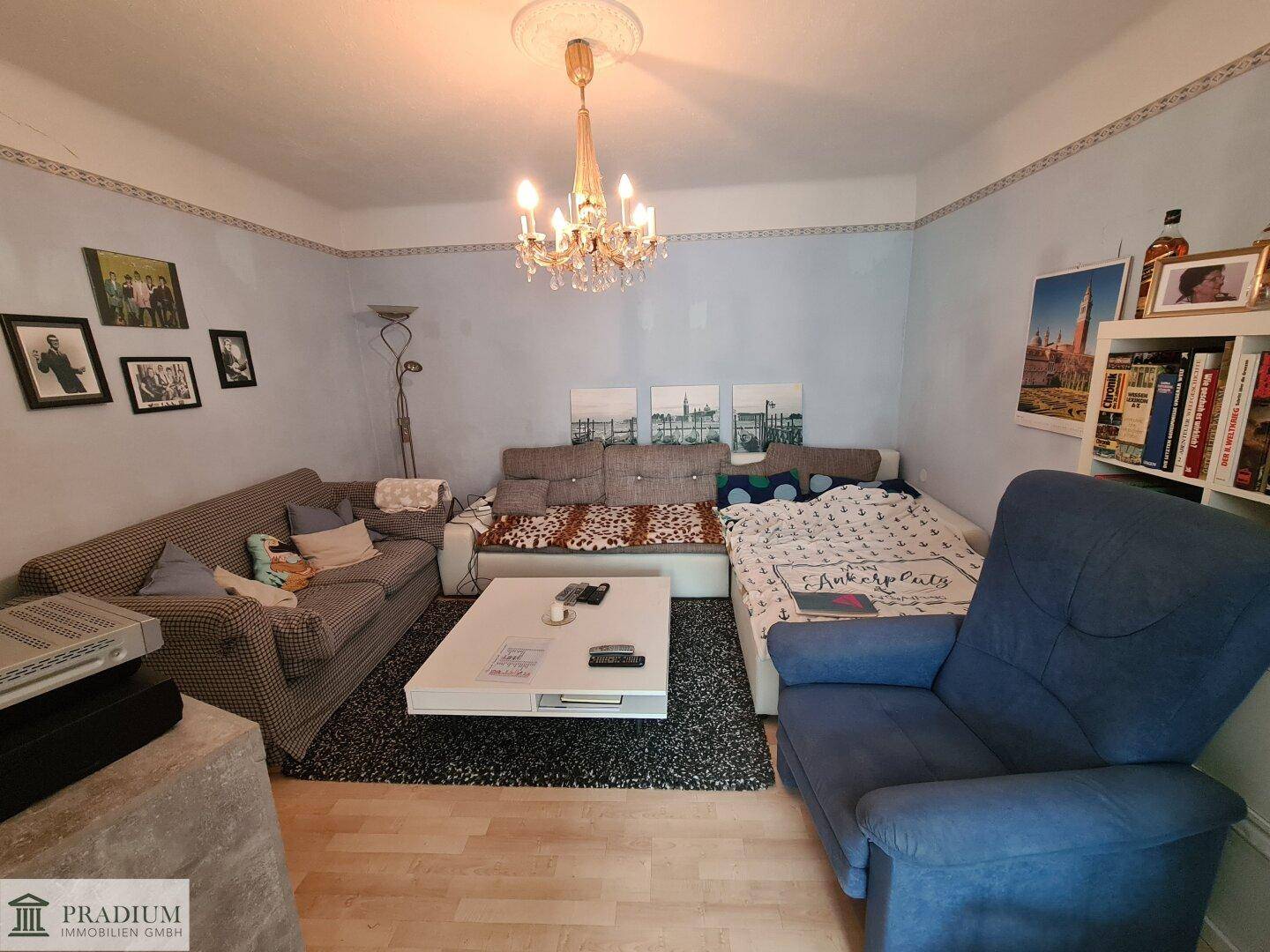 Gemütliches Wohnzimmer mit Sofa, Couchtisch und Kronleuchter, hell und einladend.