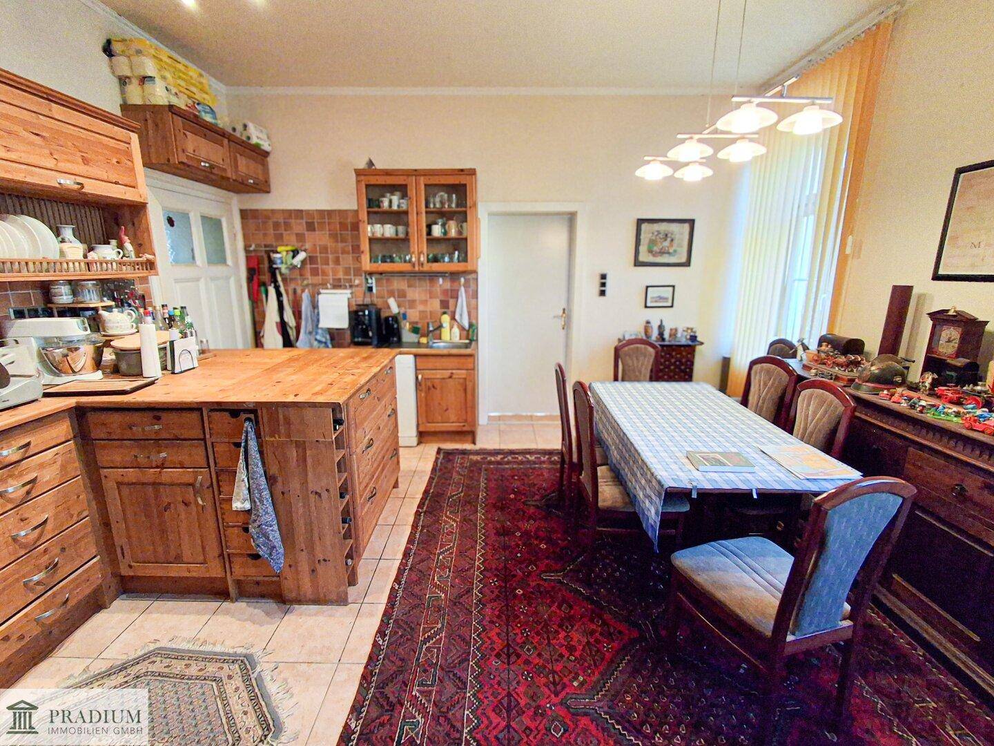 Rustikale Wohnküche mit Holzelementen, großem Esstisch und traditionellem Charme.