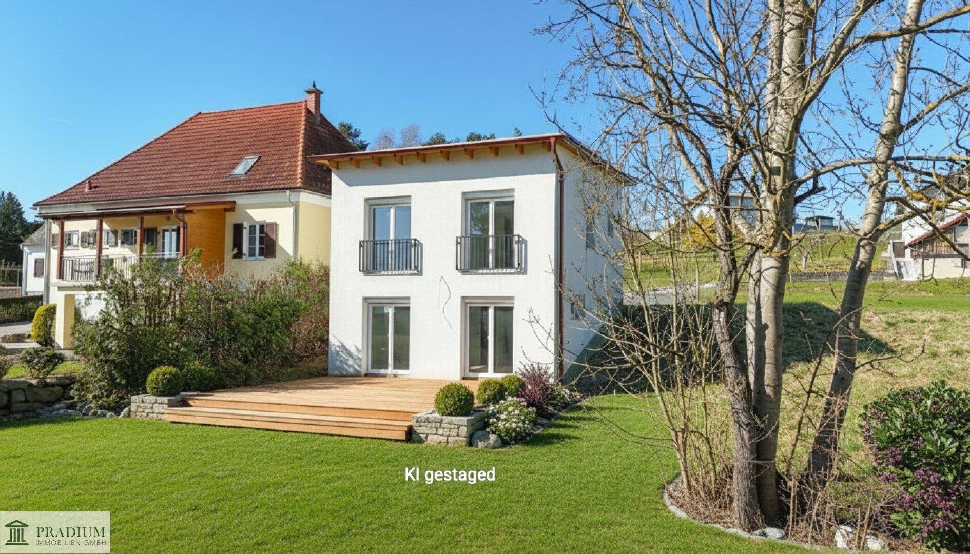 Modernes Einfamilienhaus mit weißer Fassade, großer Holzterrasse und gepflegtem Garten.