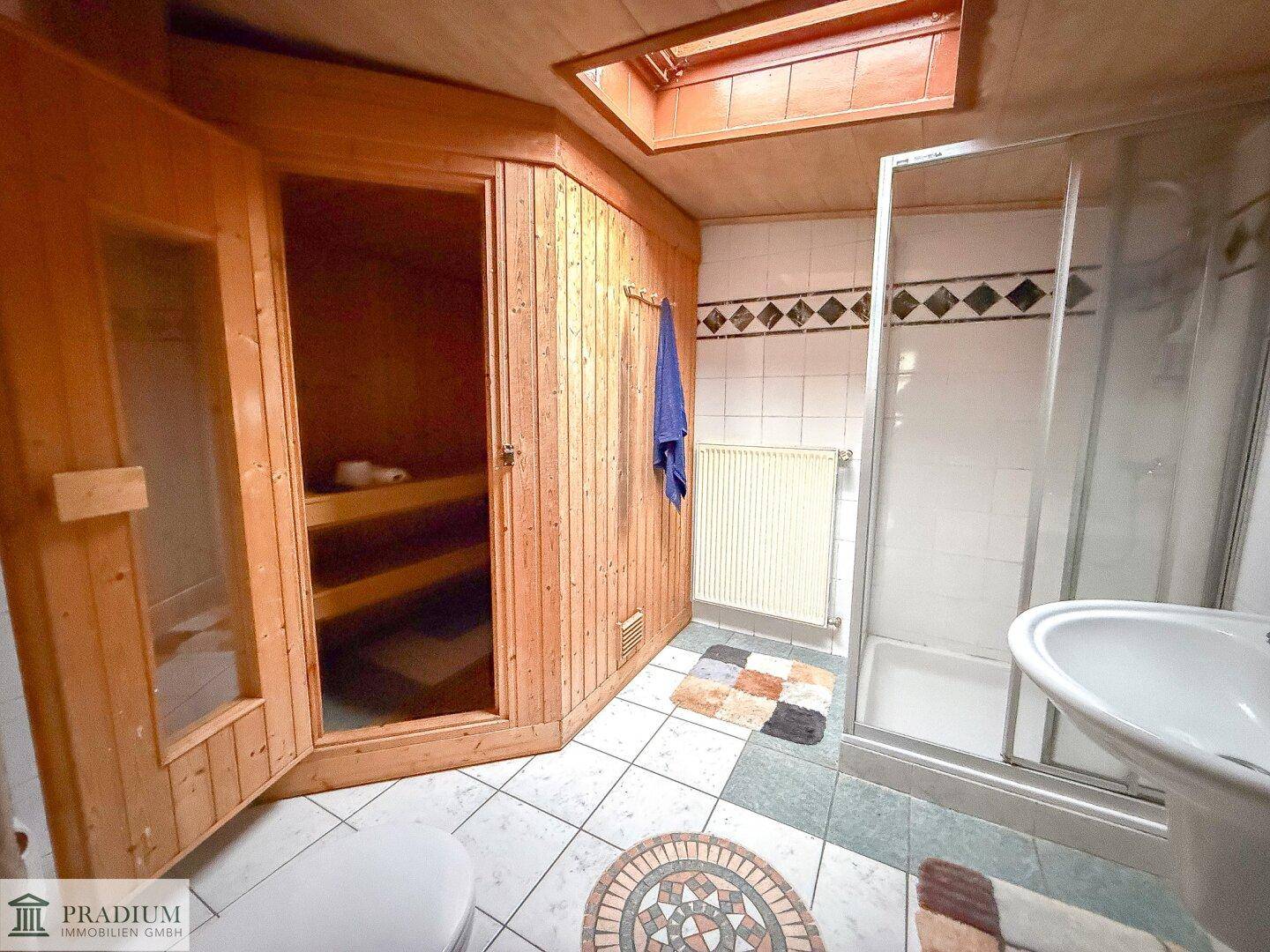 Badezimmer mit integrierter Sauna, Duschkabine und Dachfenster, bietet Entspannung und Komfort.
