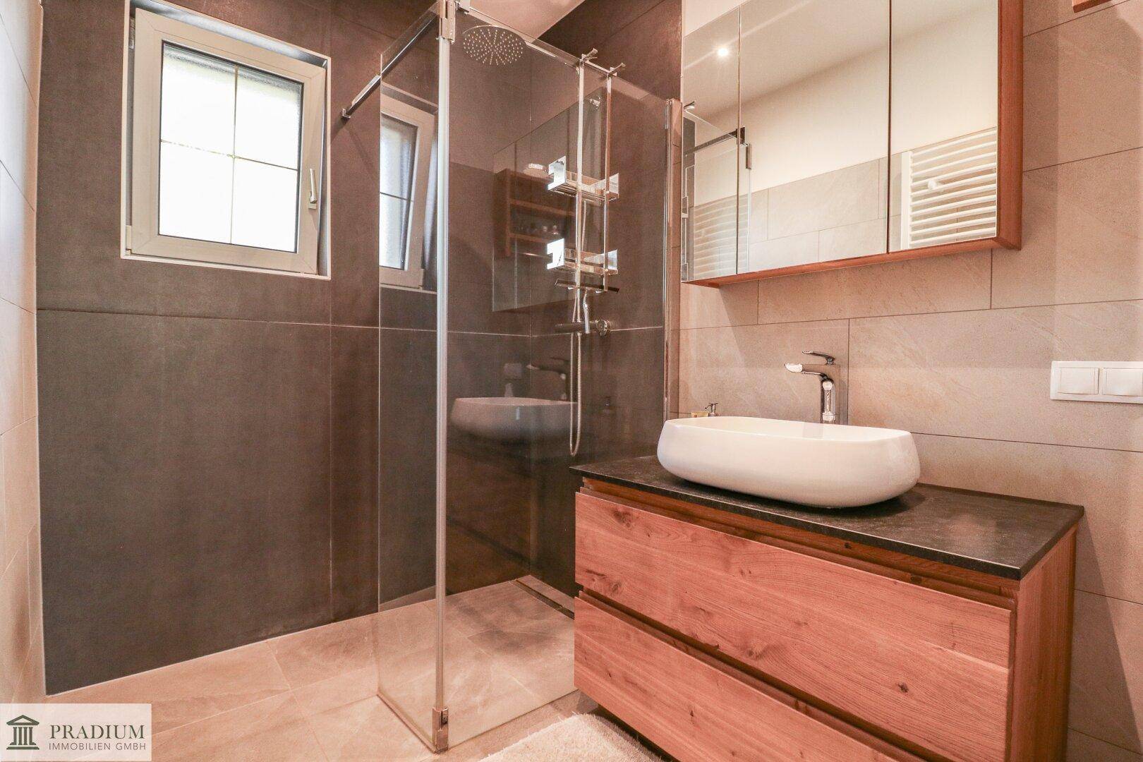 Modernes Badezimmer mit begehbarer Dusche, stilvollem Waschtisch und Fenster.