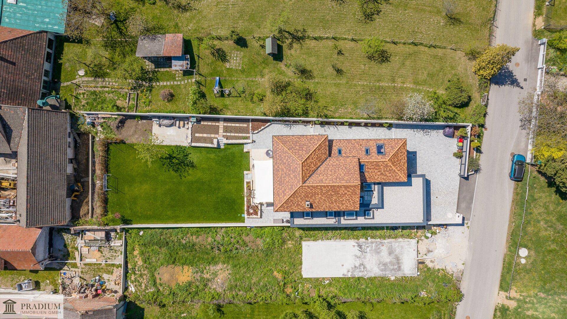 Übersicht des Anwesens von oben mit großem Garten, Garage und Zufahrt.
