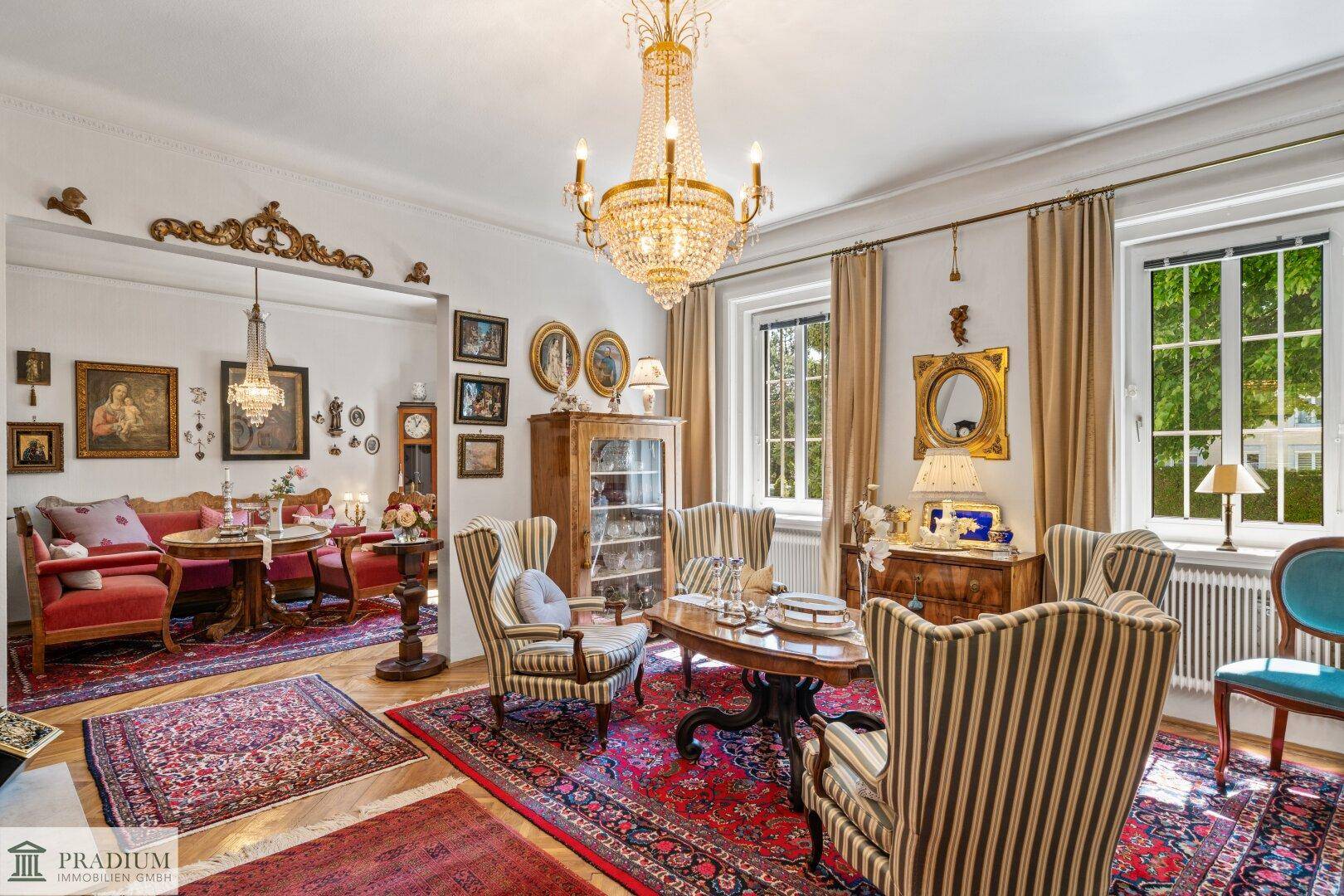 Elegantes Wohnzimmer mit antiken Möbeln, opulentem Kronleuchter und reich verzierten Teppichen.