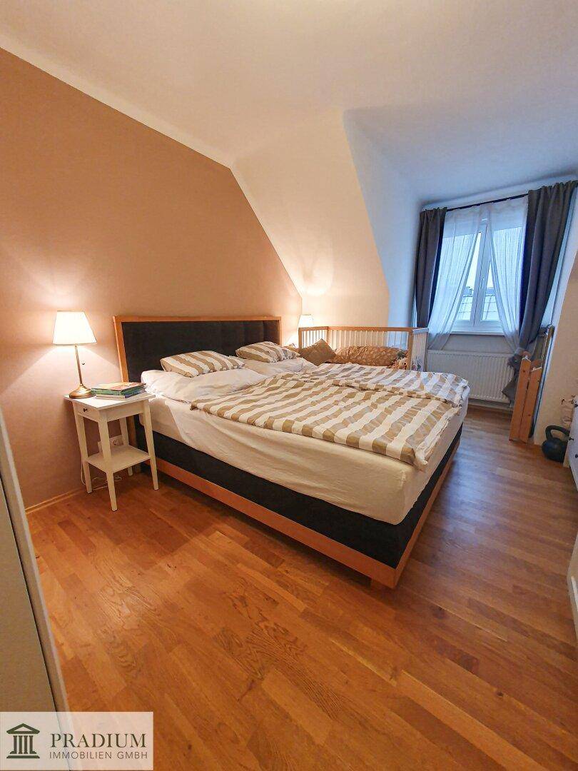 Gemütliches Schlafzimmer mit Holzboden, Doppelbett und Dachschräge für besonderen Charme.