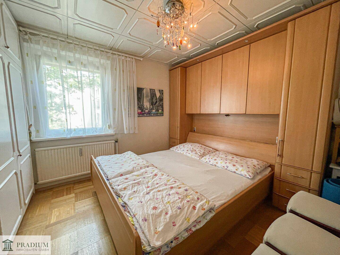 Gemütliches Schlafzimmer mit Doppelbett, Einbauschränken und dekorativer Deckenverkleidung.