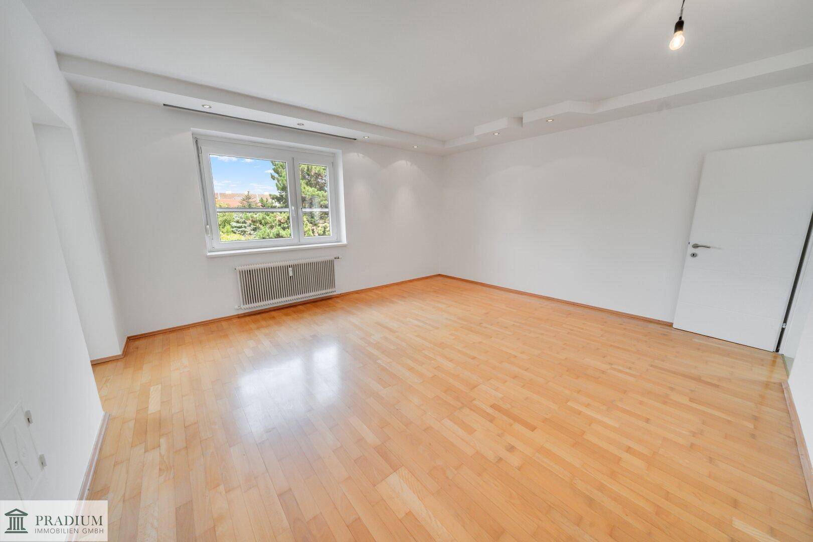 Geräumiges, helles Zimmer mit Parkettboden und großem Fenster, bereit zur individuellen Gestaltung.