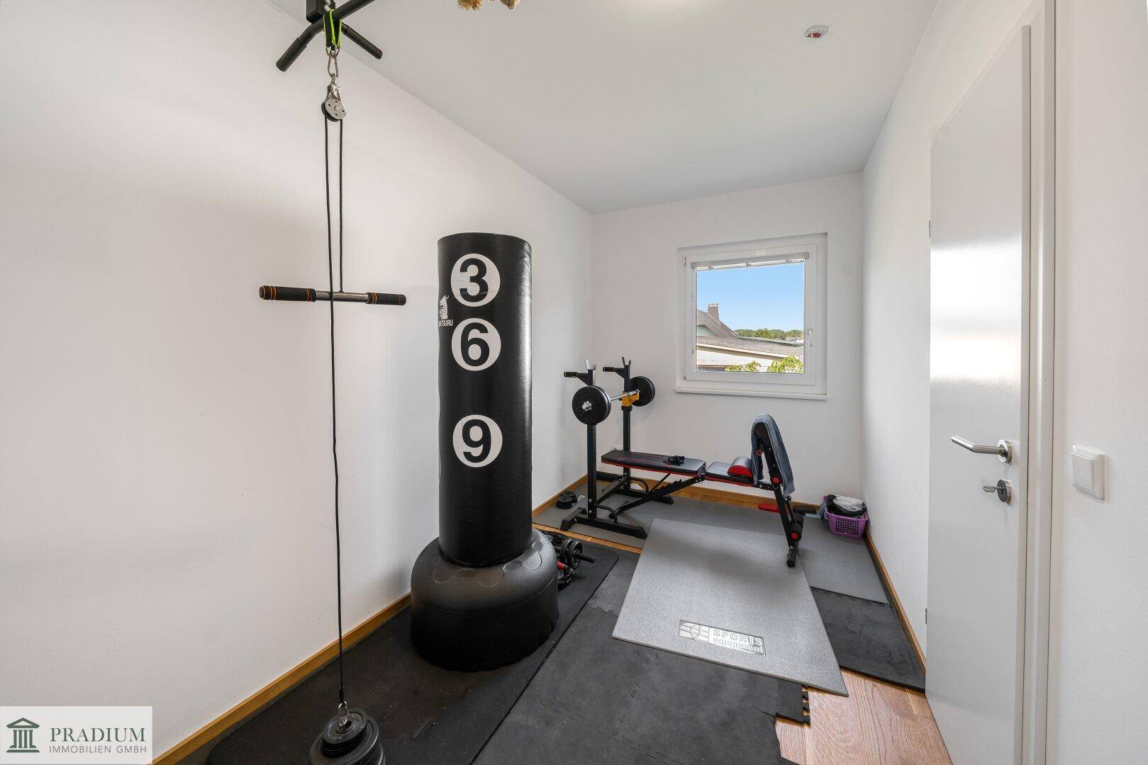 Fitnessraum mit Boxsack und Trainingsgeräten, ideal für das persönliche Workout zu Hause.