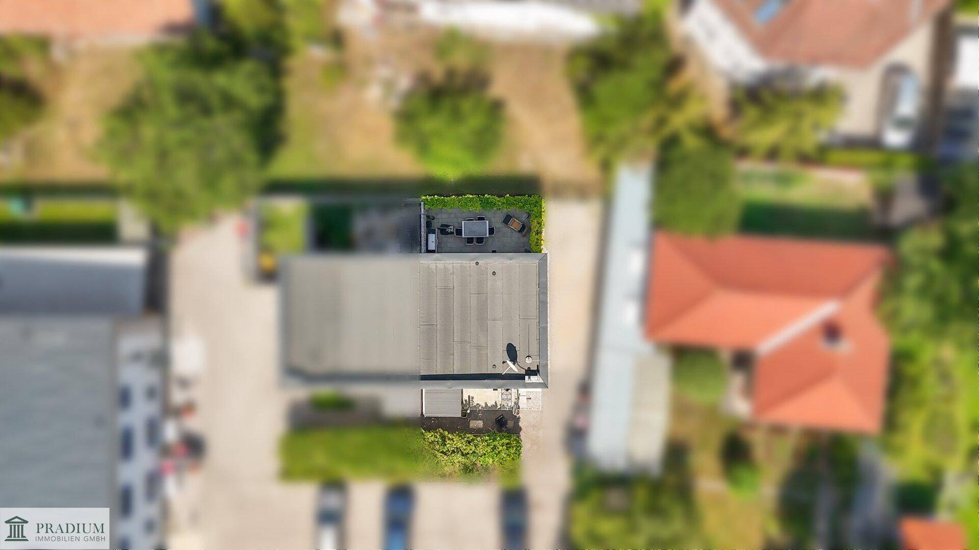 Vogelperspektive des Hauses mit Flachdach und der umliegenden Wohnbebauung.
